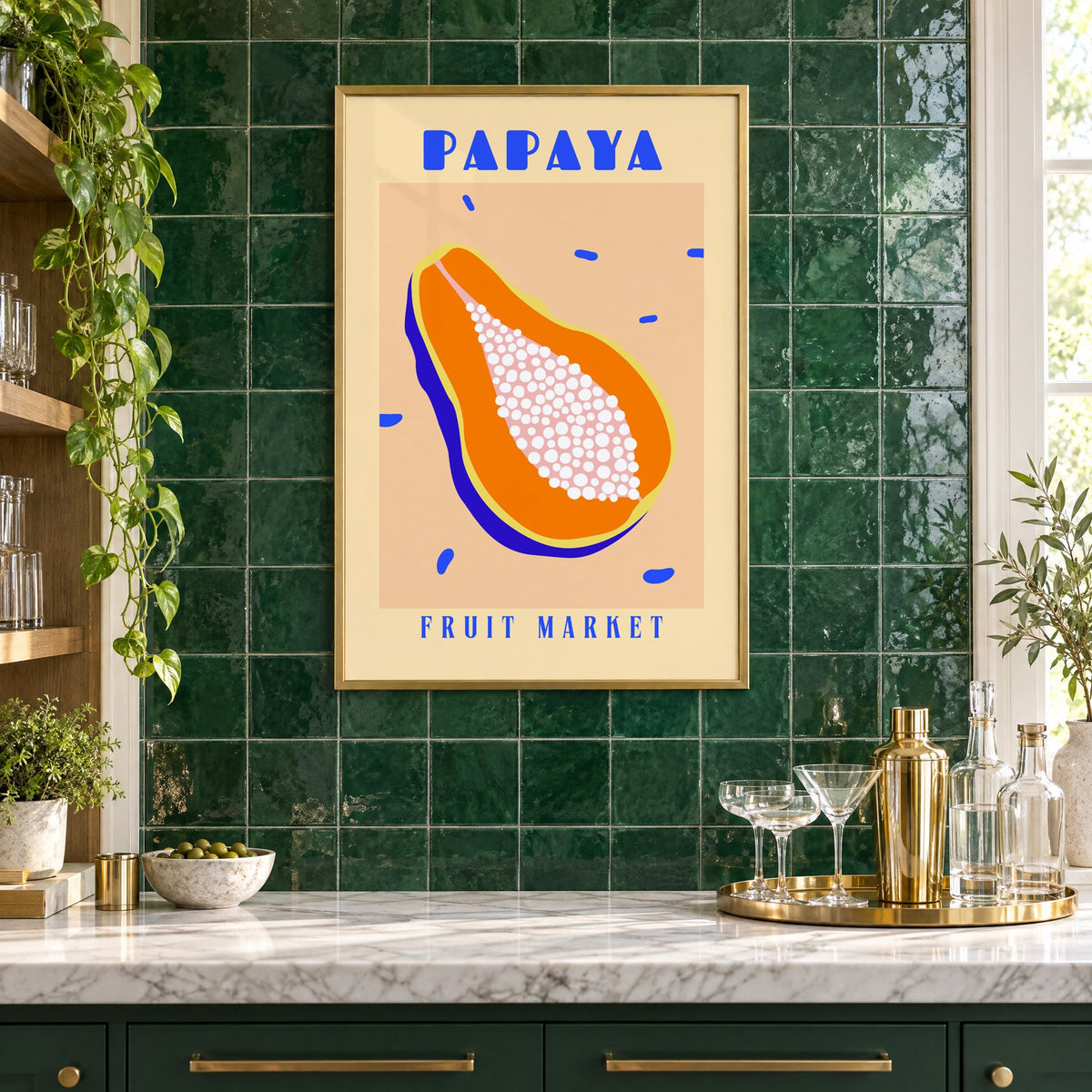 Papaya Fruit Market print in a brass frame on emerald green tiles above a home bar with coupe glasses