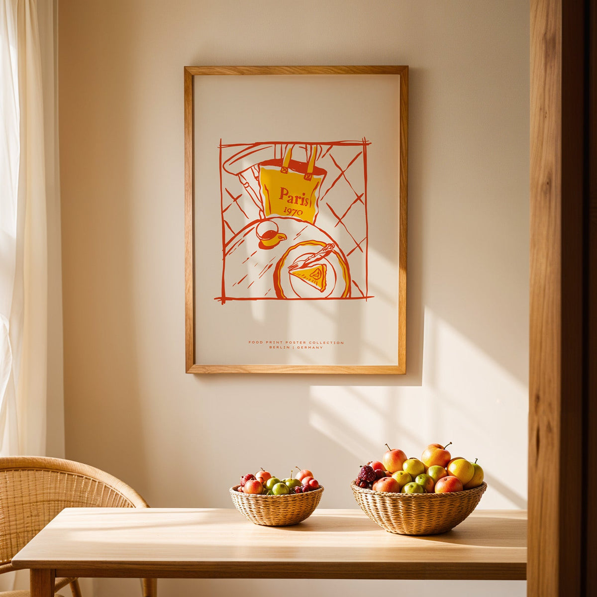 Paris cafe table print in an oak frame hanging above a dining table with rattan chairs