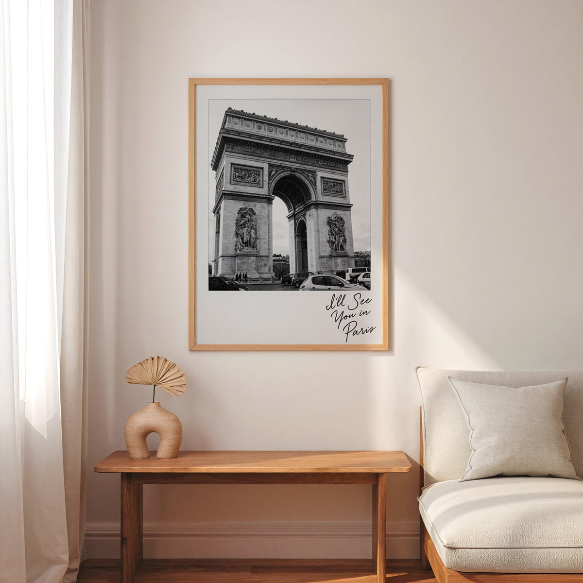 Arc de Triomphe instant photo with Paris script print in an oak frame above a narrow console with an arched vase