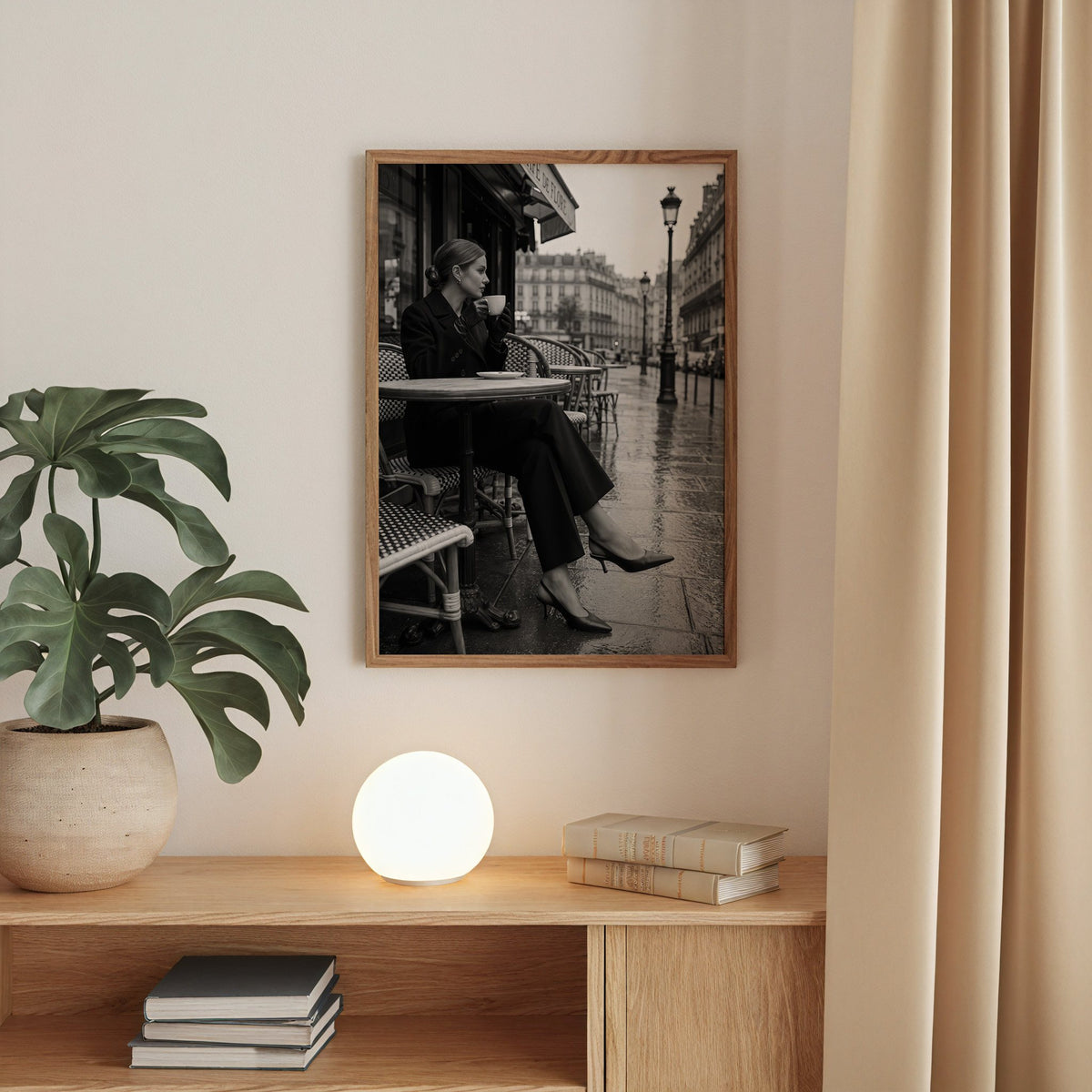 Black and white Paris cafe woman with coffee print in a walnut frame above an oak cabinet with a glowing globe lamp