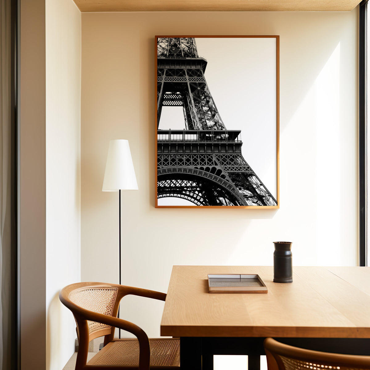 Eiffel Tower close-up on white background print in an oak frame above a dining table and cane chair