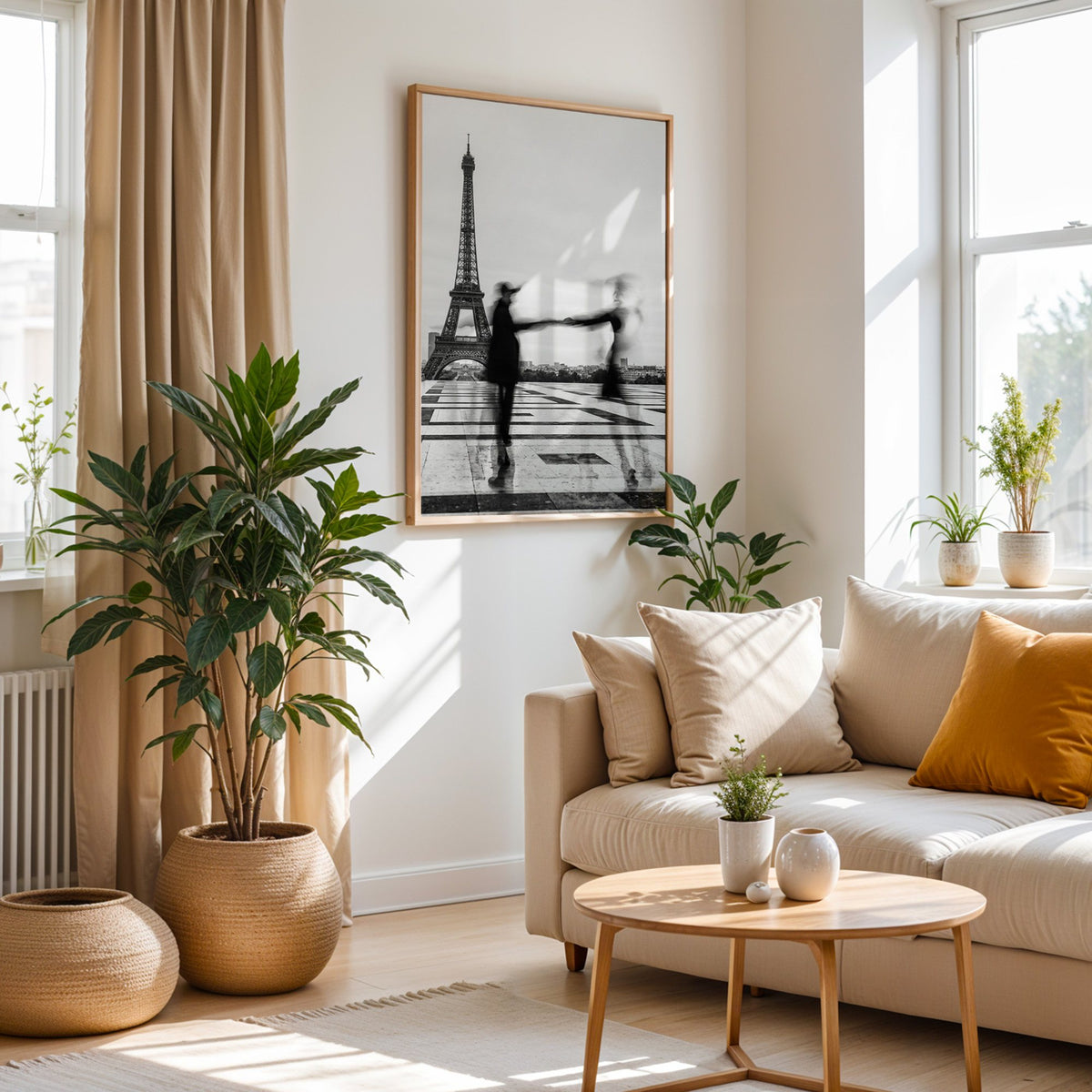 Blurred couple twirling near the Eiffel Tower print in an oak frame above a cream sofa beside woven planters