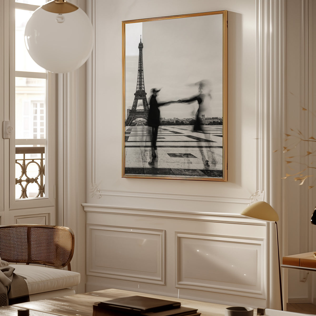 Blurred couple twirling near the Eiffel Tower print shown in a gold frame in a Parisian paneled living room