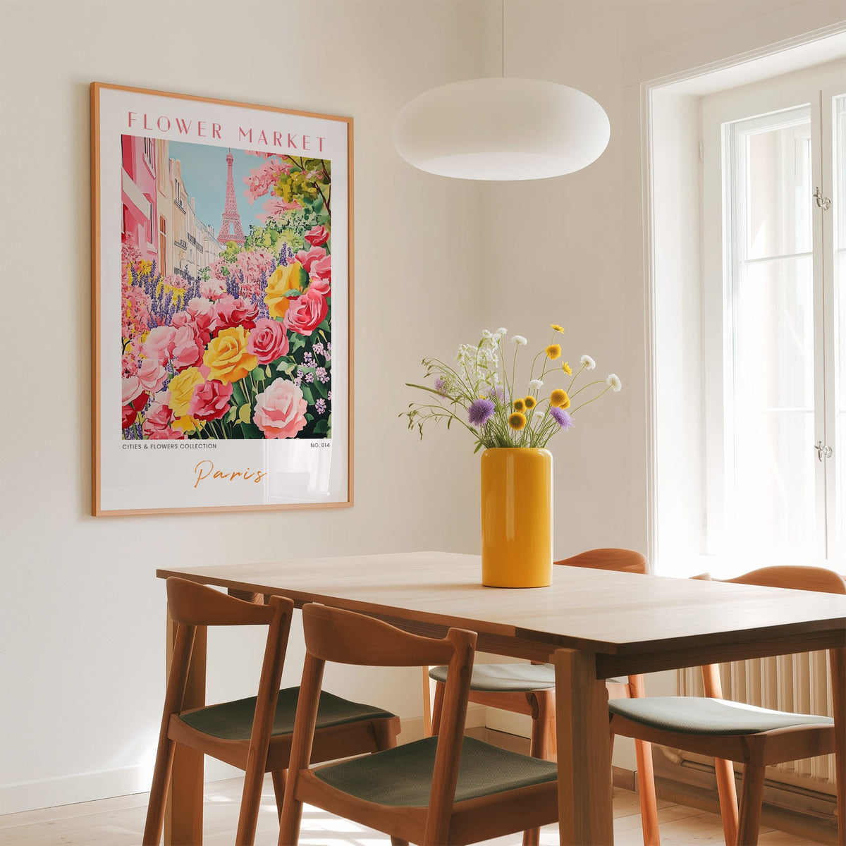 Paris flower market print in an oak frame above a dining table with a yellow vase and white pendant light