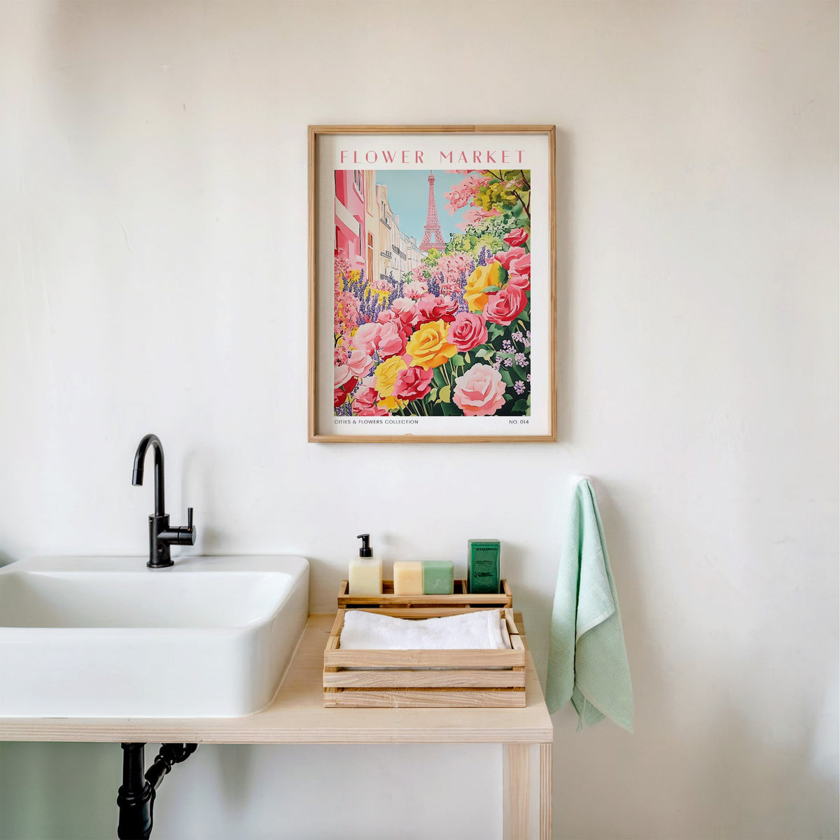 Paris flower market print in an oak frame above a white bathroom sink with folded towels