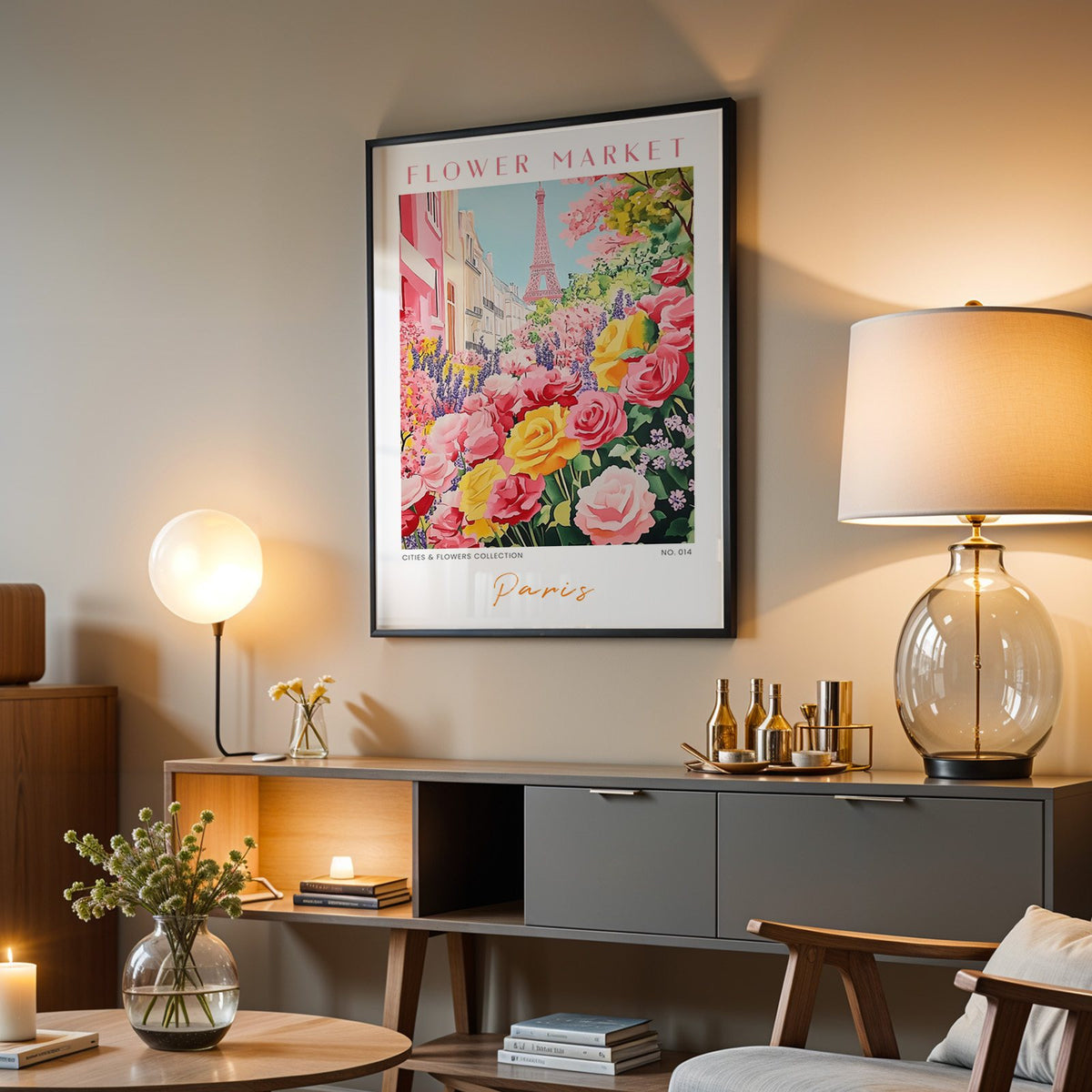 Paris flower market print in a black frame above a grey media console with a glass table lamp