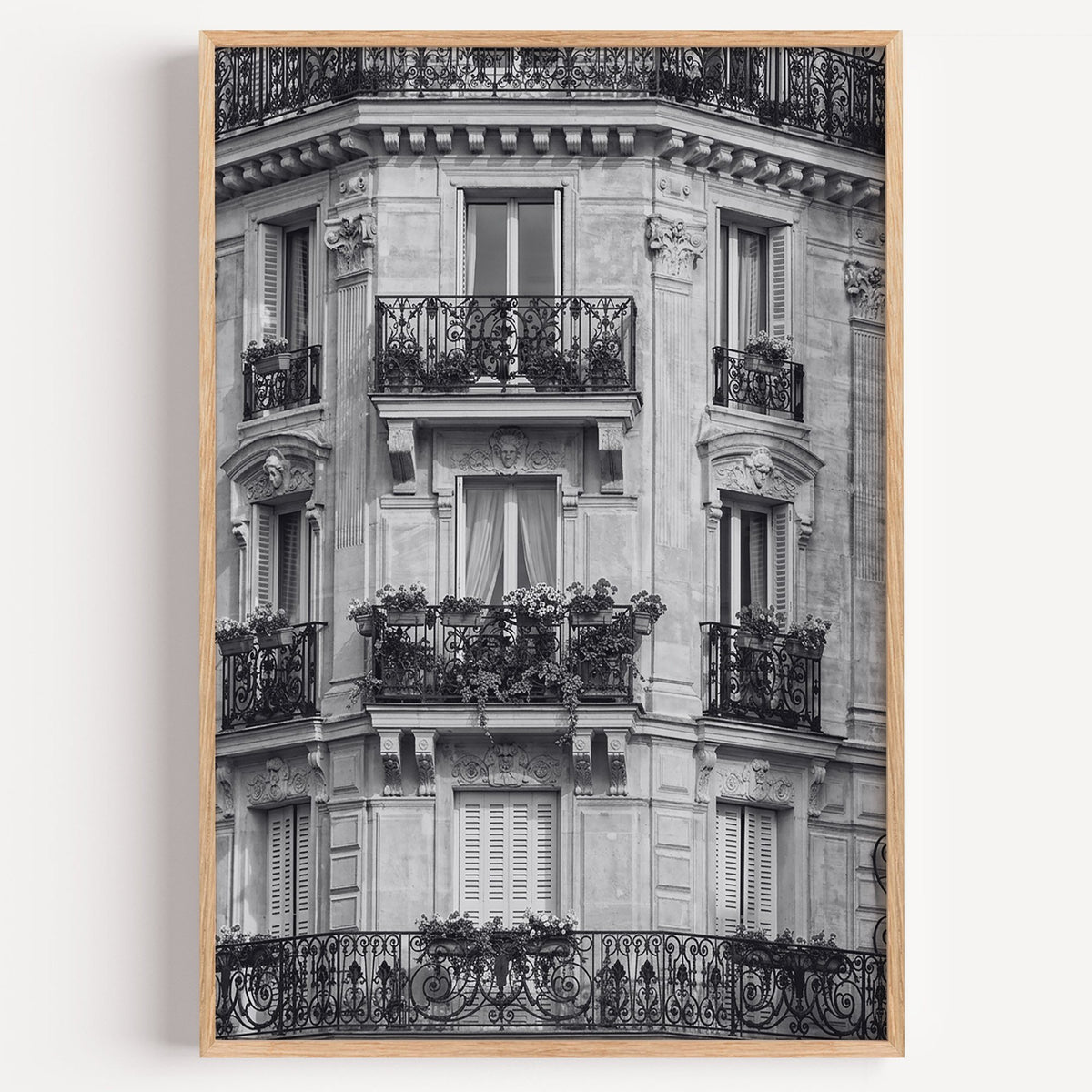Paris facade with wrought iron balconies print in a light oak frame on a plain white wall