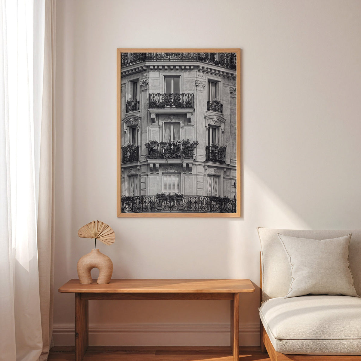 Paris facade with wrought iron balconies print in an oak frame above a narrow console with an arched vase