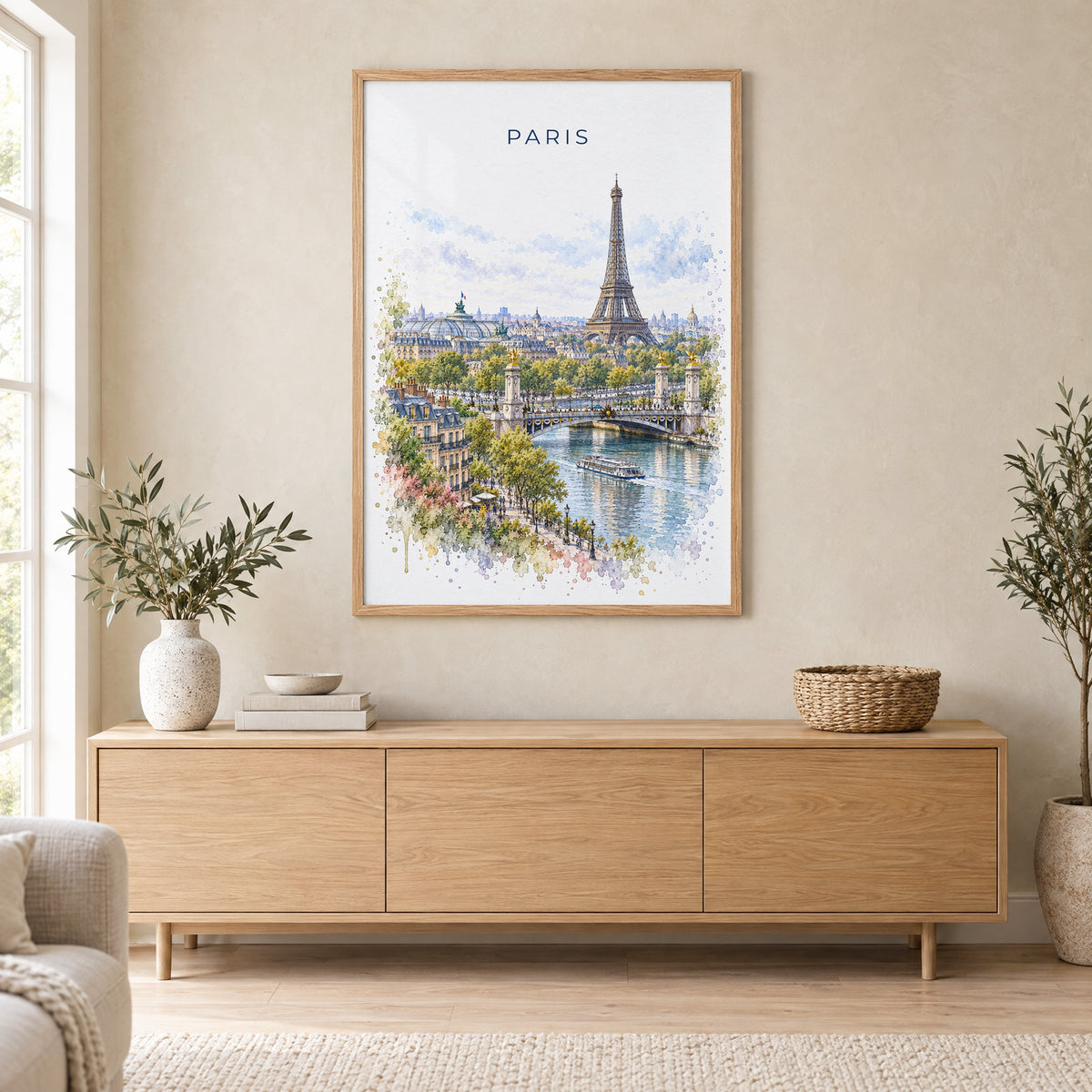 Paris watercolor print in an oak frame above a light wood sideboard in a Scandinavian living room