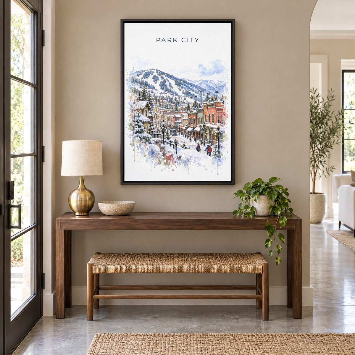 Park City watercolor print as a black floater canvas above a walnut console and woven bench in an entryway