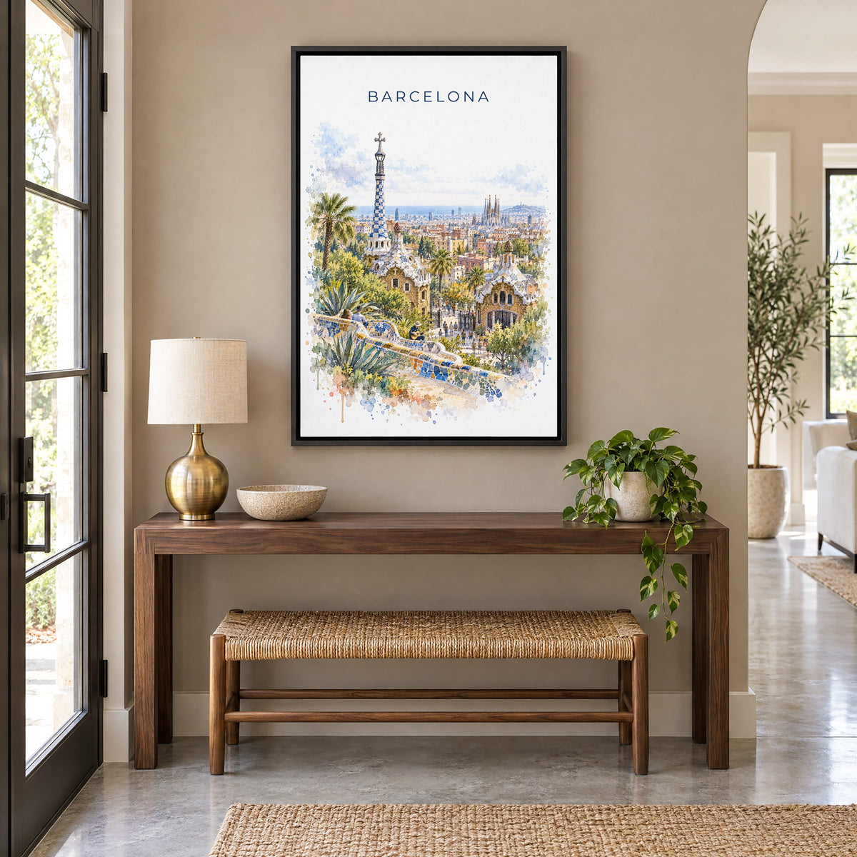 Park Güell watercolor print as a black floater canvas above a walnut console and woven bench in an entryway