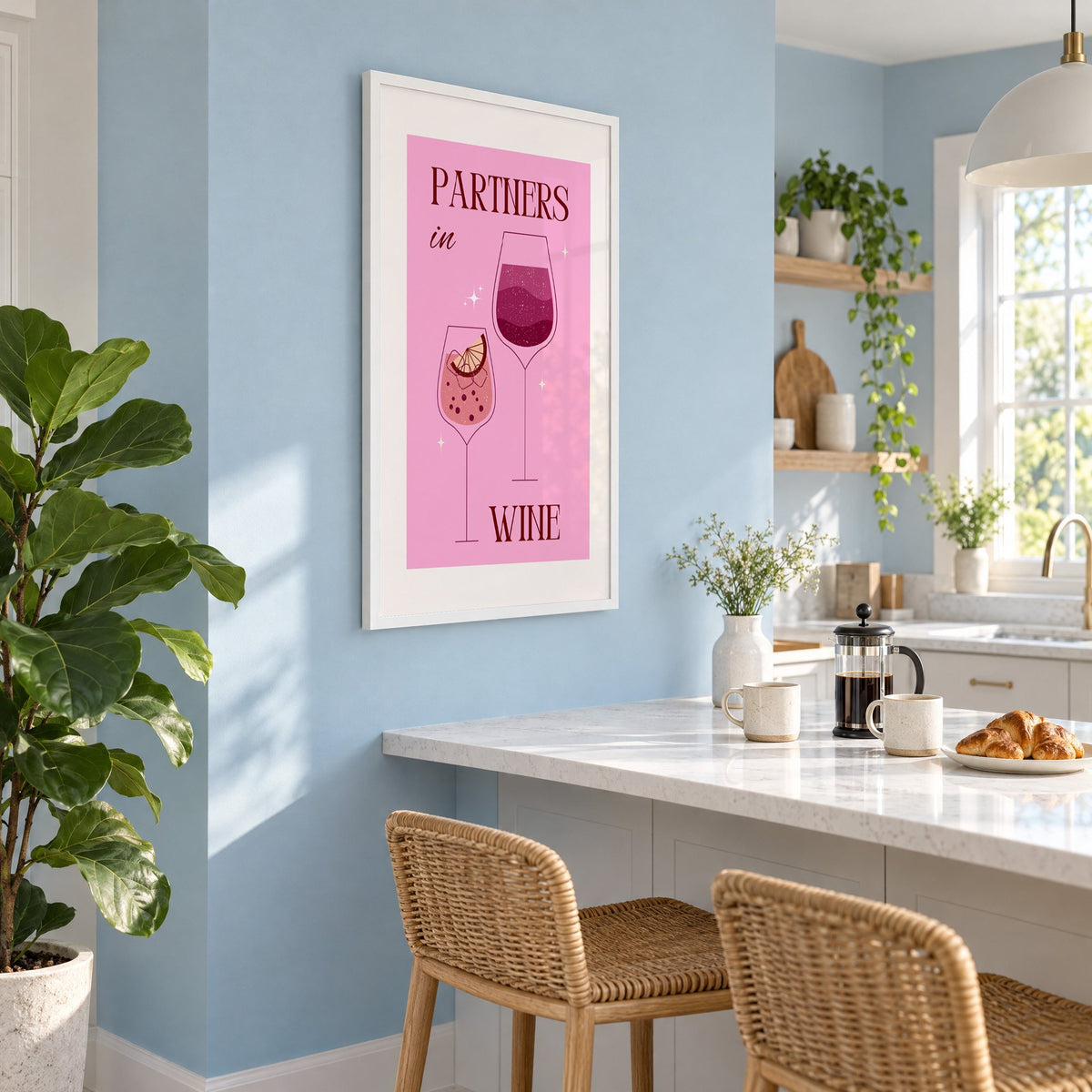 Partners in Wine two glasses pink print in a white frame on a pale blue wall above a breakfast bar with rattan stools