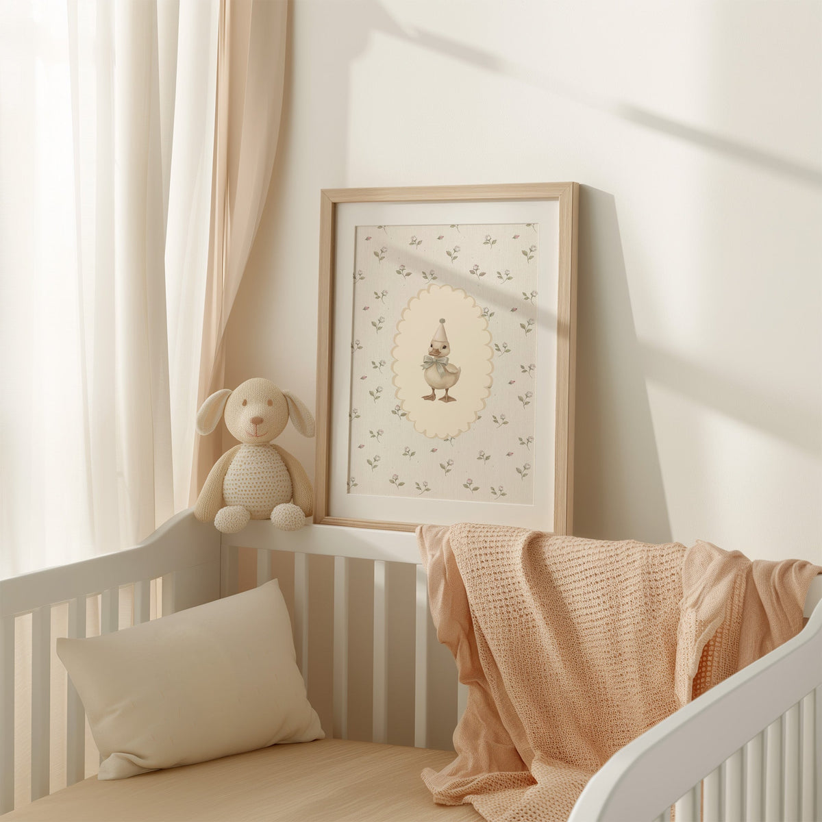 Party duckling in cream oval on rosebuds nursery print shown in an oak frame with a white mat on a crib rail