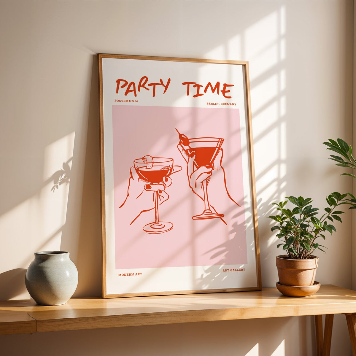 Party Time cocktail toast print in a slim oak frame on a console with a grey-blue vase