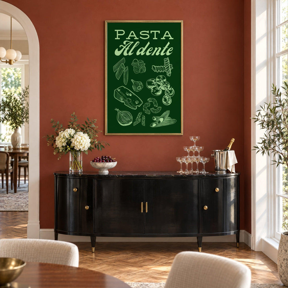 Pasta Al dente engraved green print in a brass frame on a terracotta wall above a black buffet with a champagne tower
