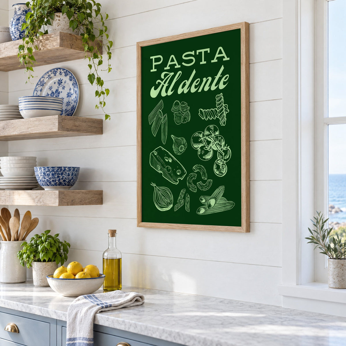 Pasta Al dente engraved green print in an oak frame in a white coastal kitchen beside blue and white plates
