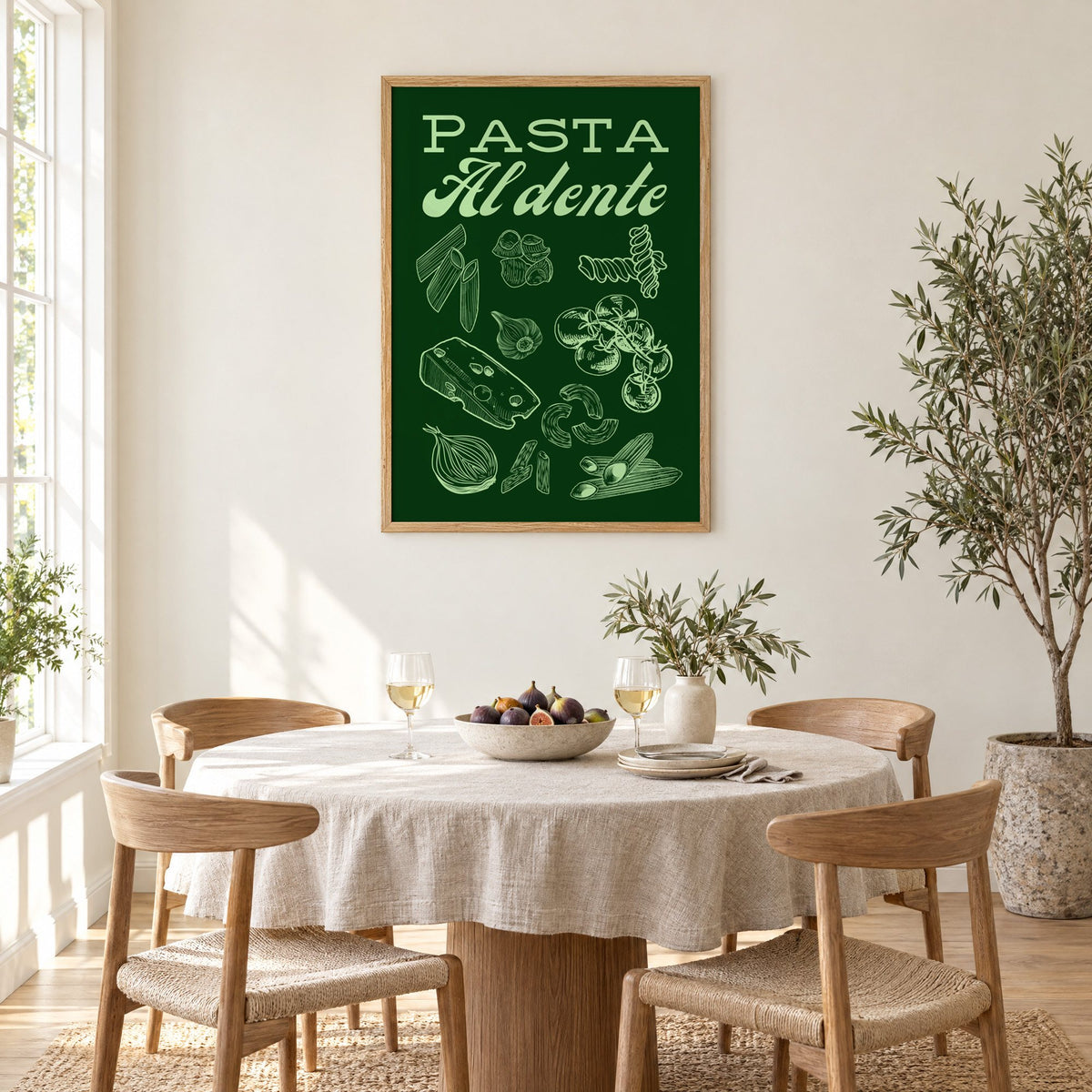 Pasta Al dente engraved green print in an oak frame above a round linen-covered dining table with figs and wine
