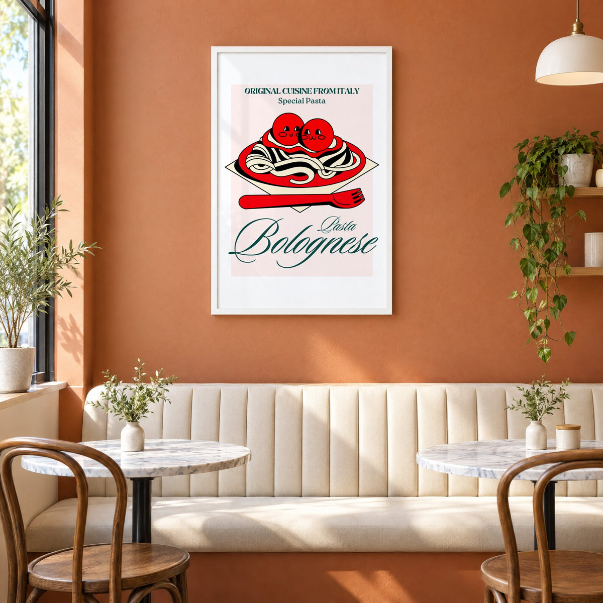 Pasta Bolognese smiling meatballs print in a white frame above a cream banquette on a terracotta cafe wall