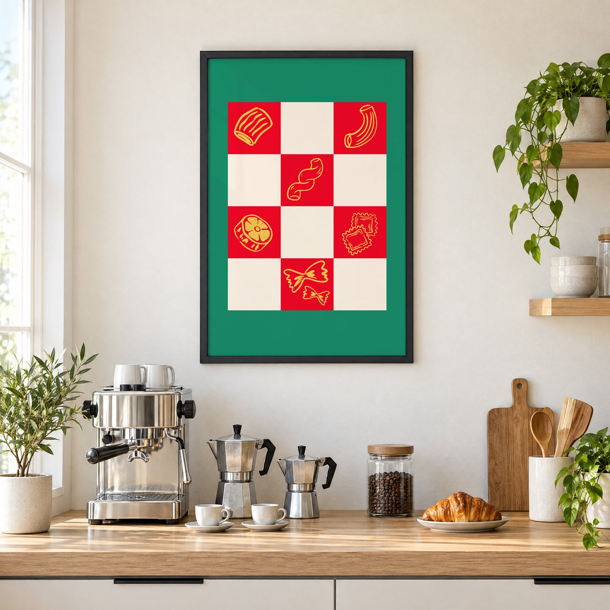 Red checkerboard pasta shapes print with green border in a black frame above a home espresso bar with moka pots and espresso cups