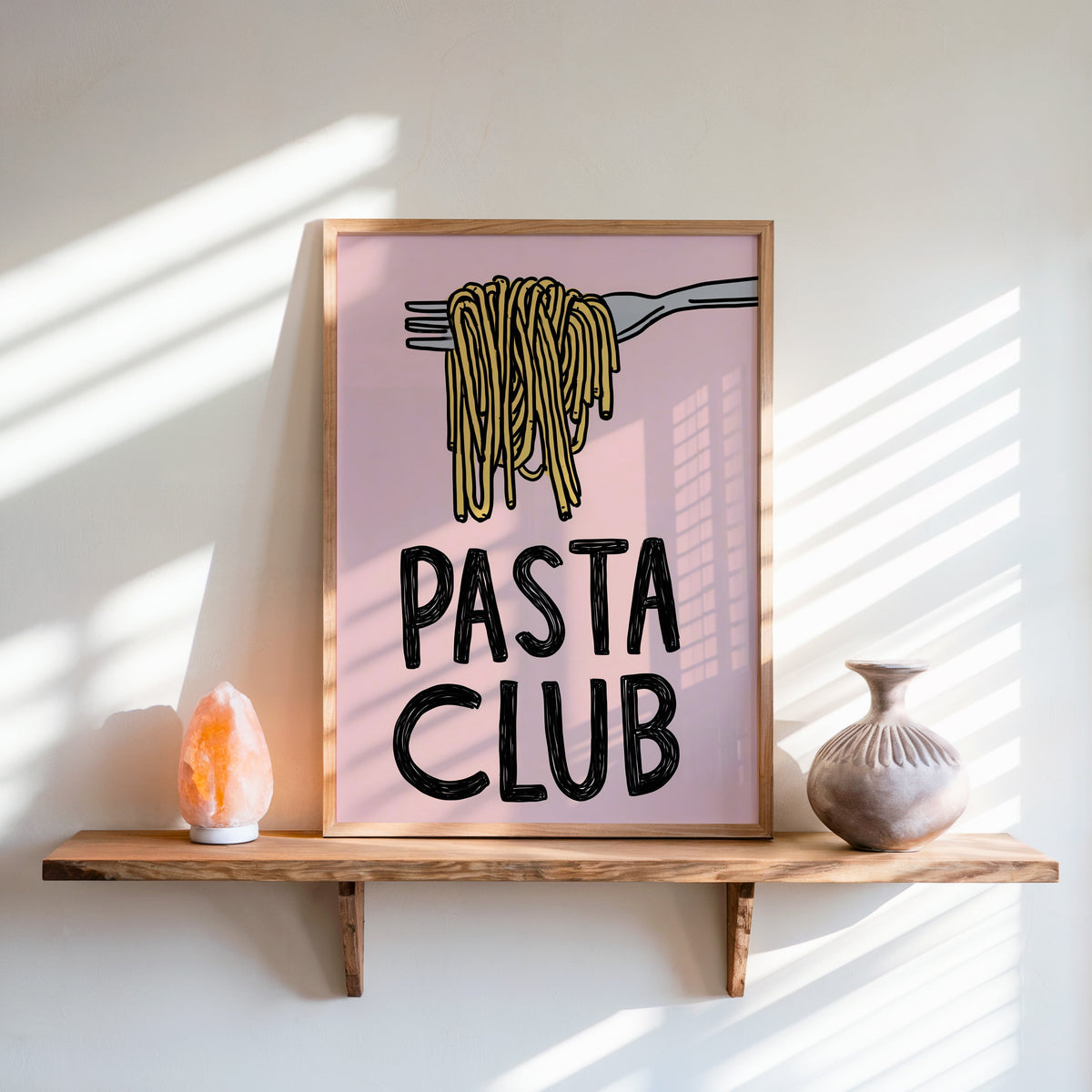 Pasta Club print in an oak frame on a live-edge shelf beside a salt lamp