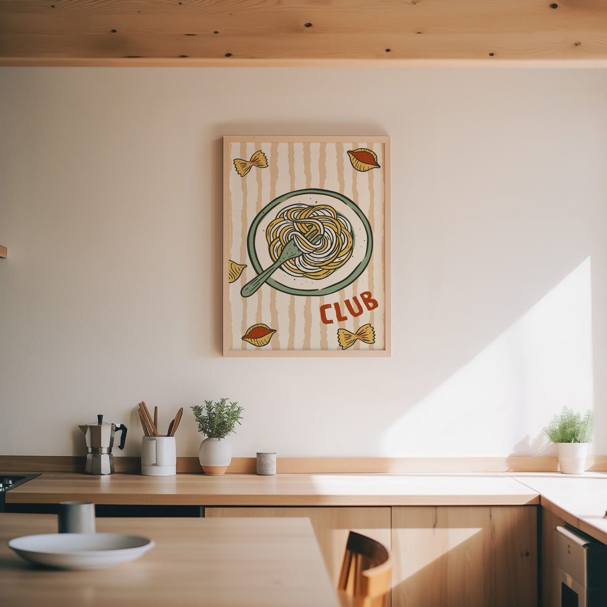 Pasta Club print in an oak frame above a wood counter with a moka pot and herbs