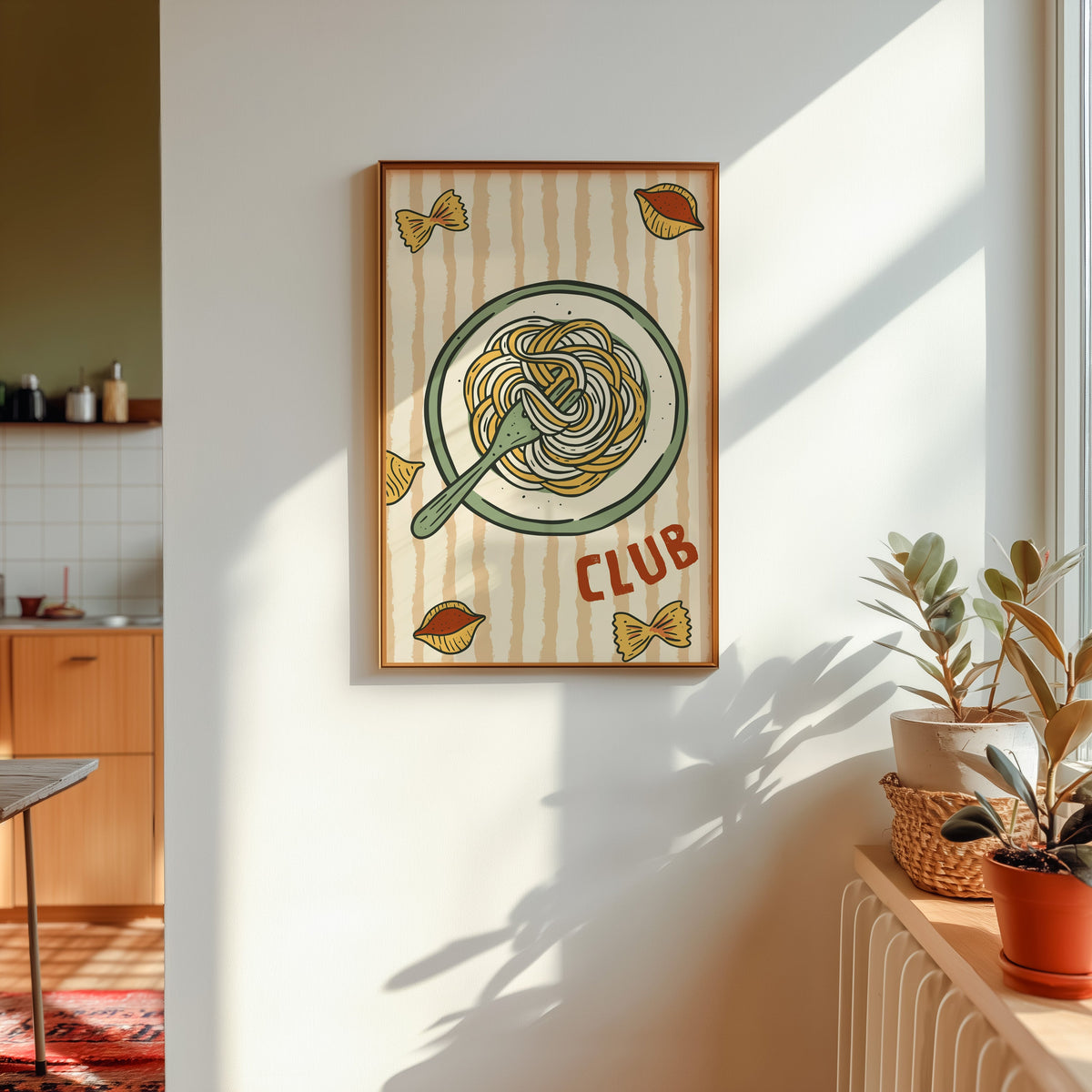 Pasta Club print in a gold frame in sunlight with plants and a kitchen beyond