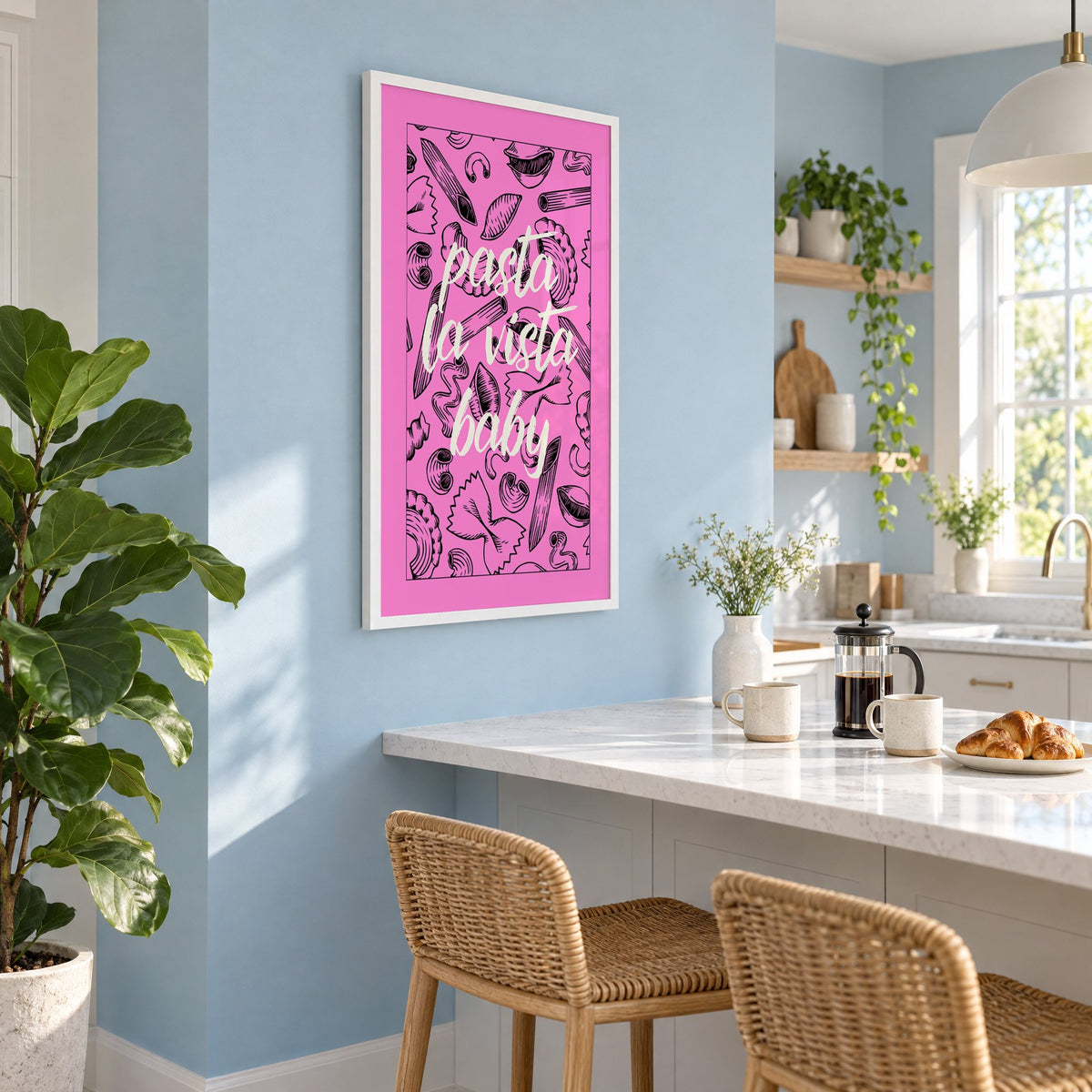Pasta la vista baby pink print in a white frame on a pale blue wall above a breakfast bar with rattan stools