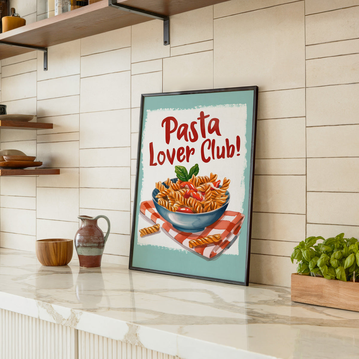 Pasta Lover Club fusilli print in a black frame leaning on a marble counter in a tiled kitchen