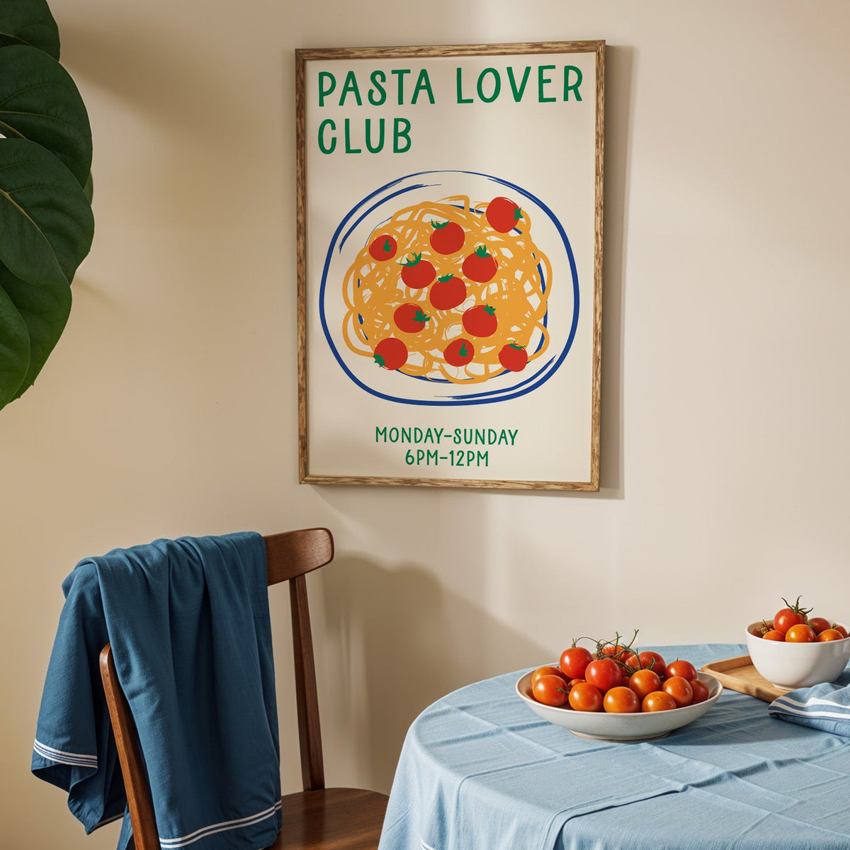 Pasta lover club print in an oak frame above a blue linen table with ripe tomatoes