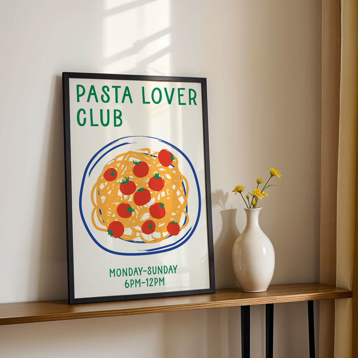 Pasta lover club print in a black frame on a console table with yellow daisies