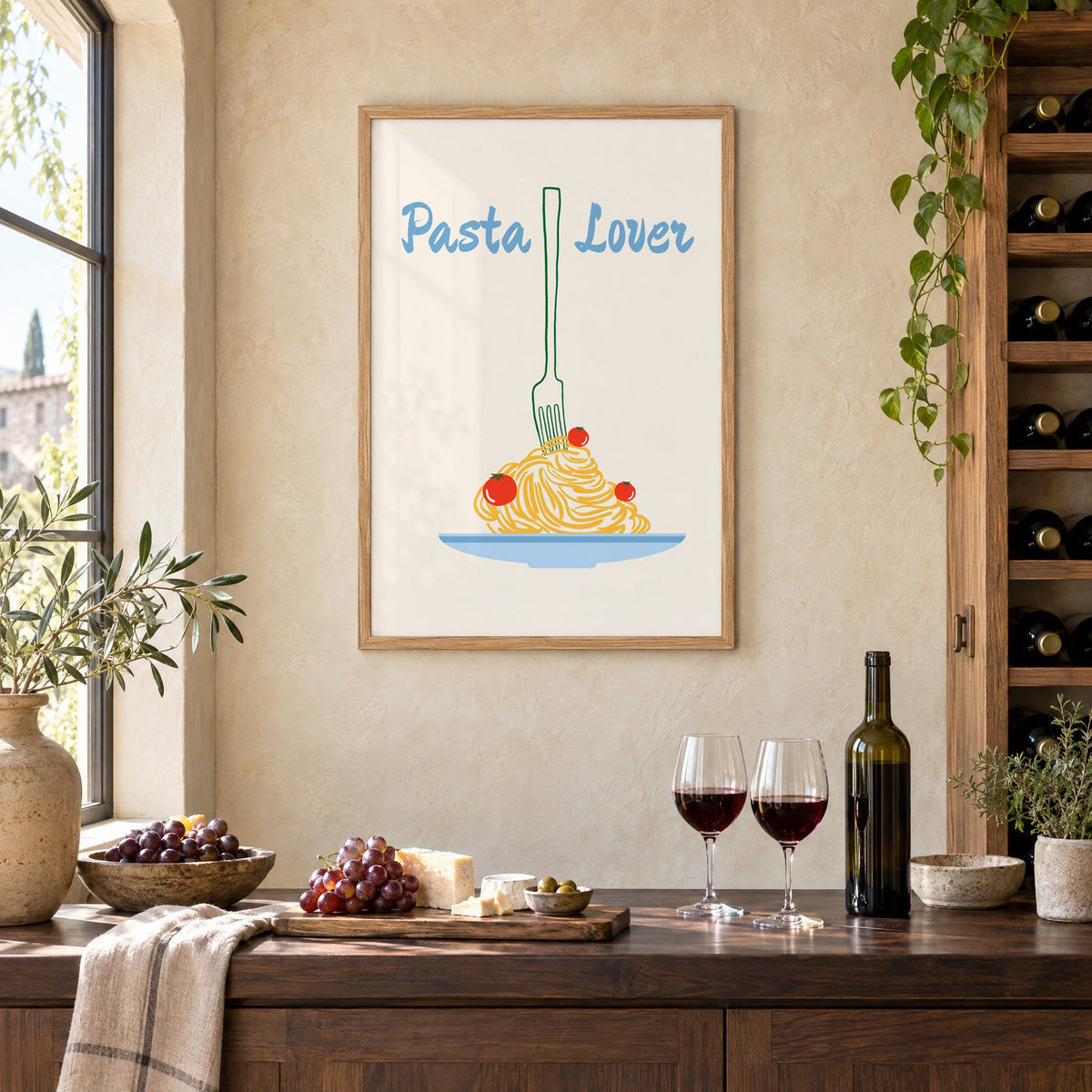 Pasta Lover fork and spaghetti print in an oak frame on a limewashed wall above a wine counter with red wine, cheese and grapes