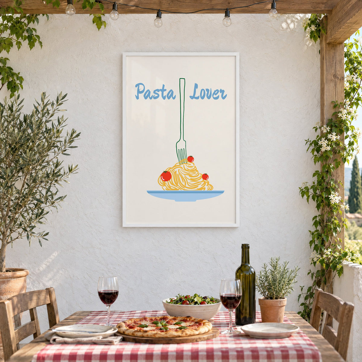 Pasta Lover fork and spaghetti print in a white frame on a stucco wall above a checked-cloth table with pizza and red wine