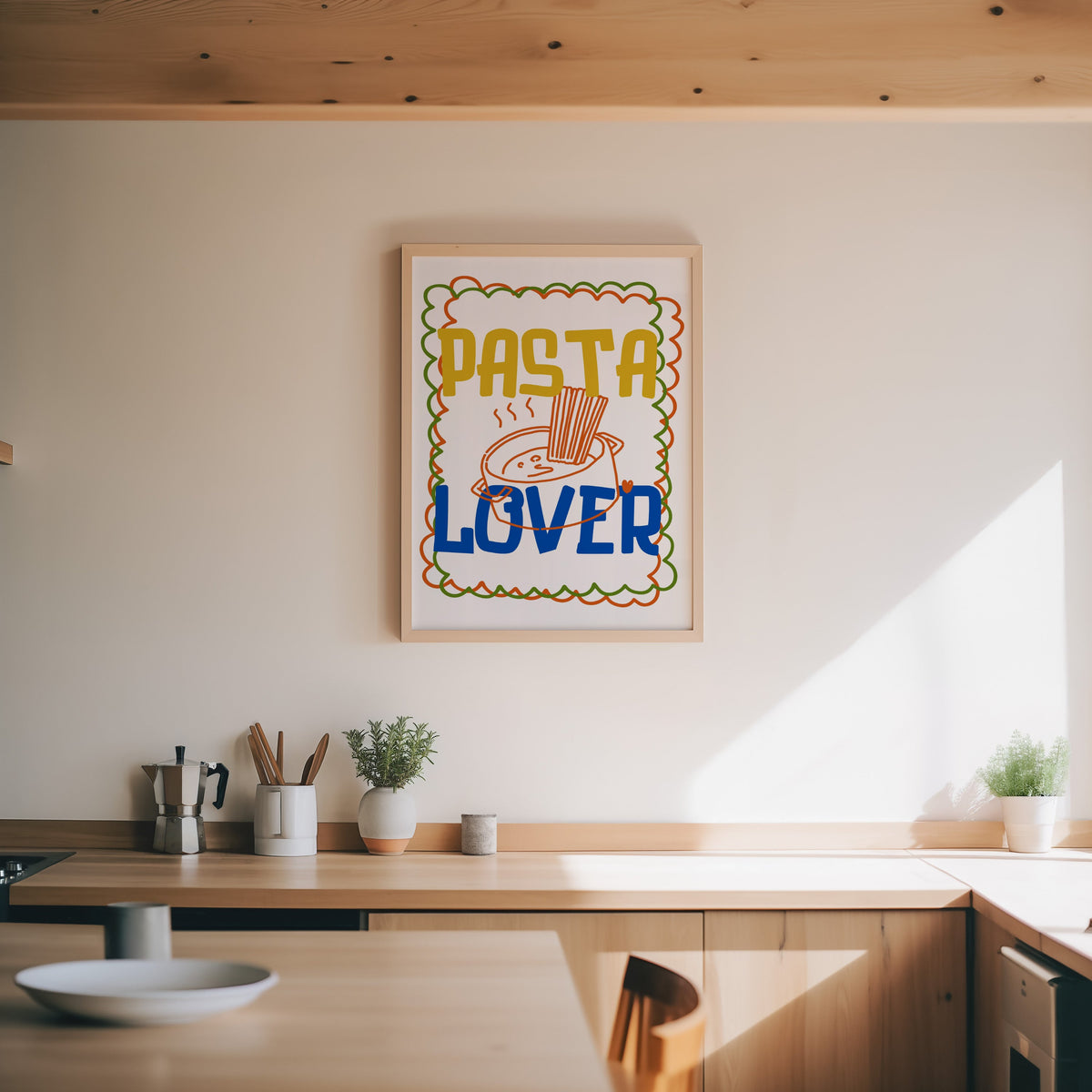 Pasta Lover print in an oak frame above a wood counter with a moka pot and herbs