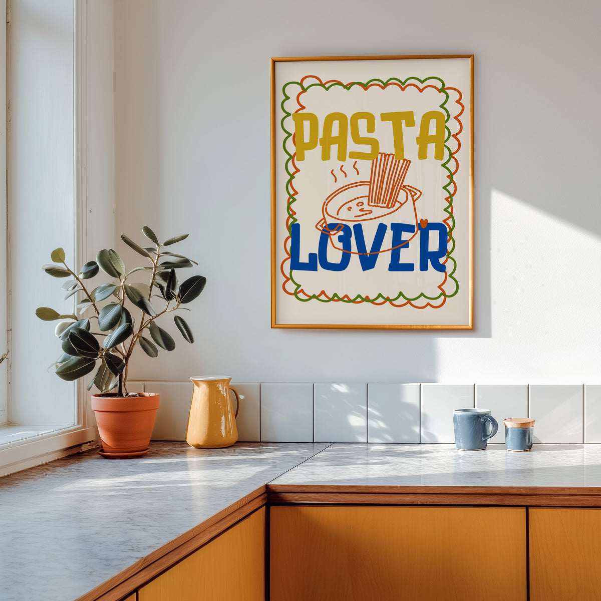 Pasta Lover print shown in a gold frame above a marble counter with a yellow ceramic jug