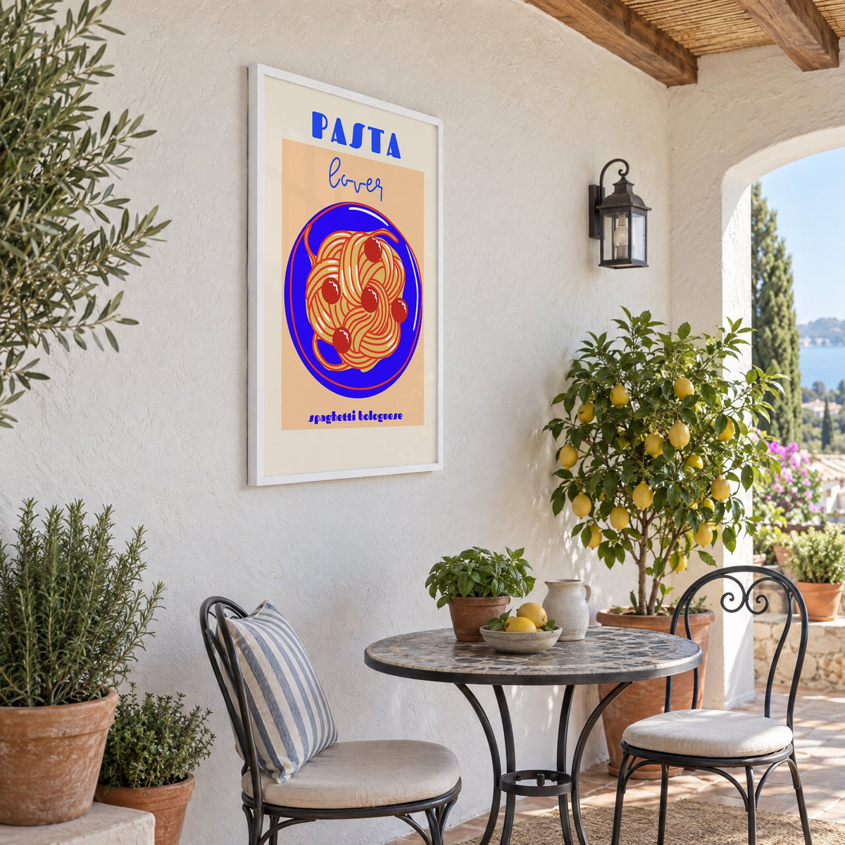 Pasta lover blue plate spaghetti print in a white frame on a sunny patio wall beside a potted lemon tree