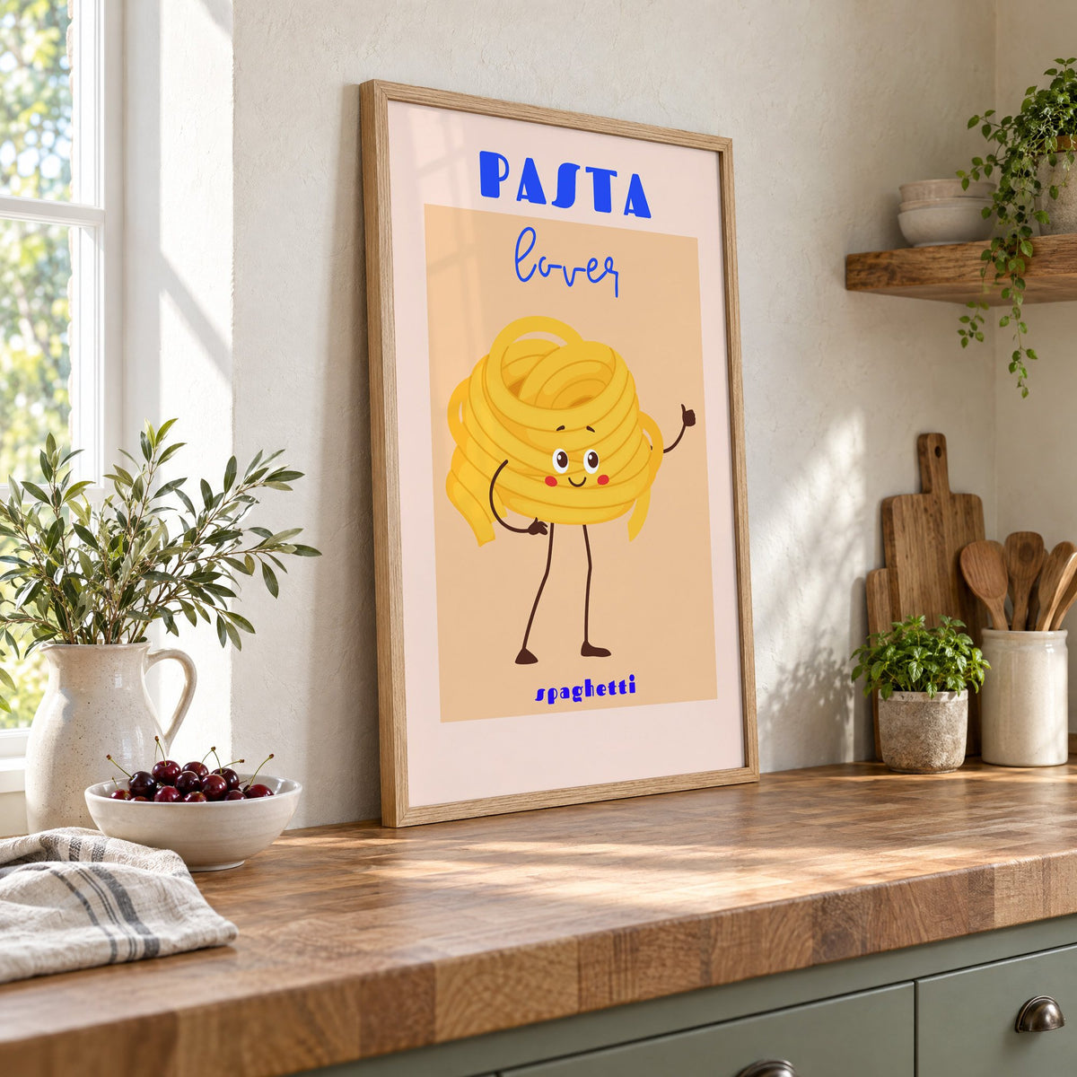 Pasta lover spaghetti character print in an oak frame leaning on a butcher block island beside a bowl of cherries
