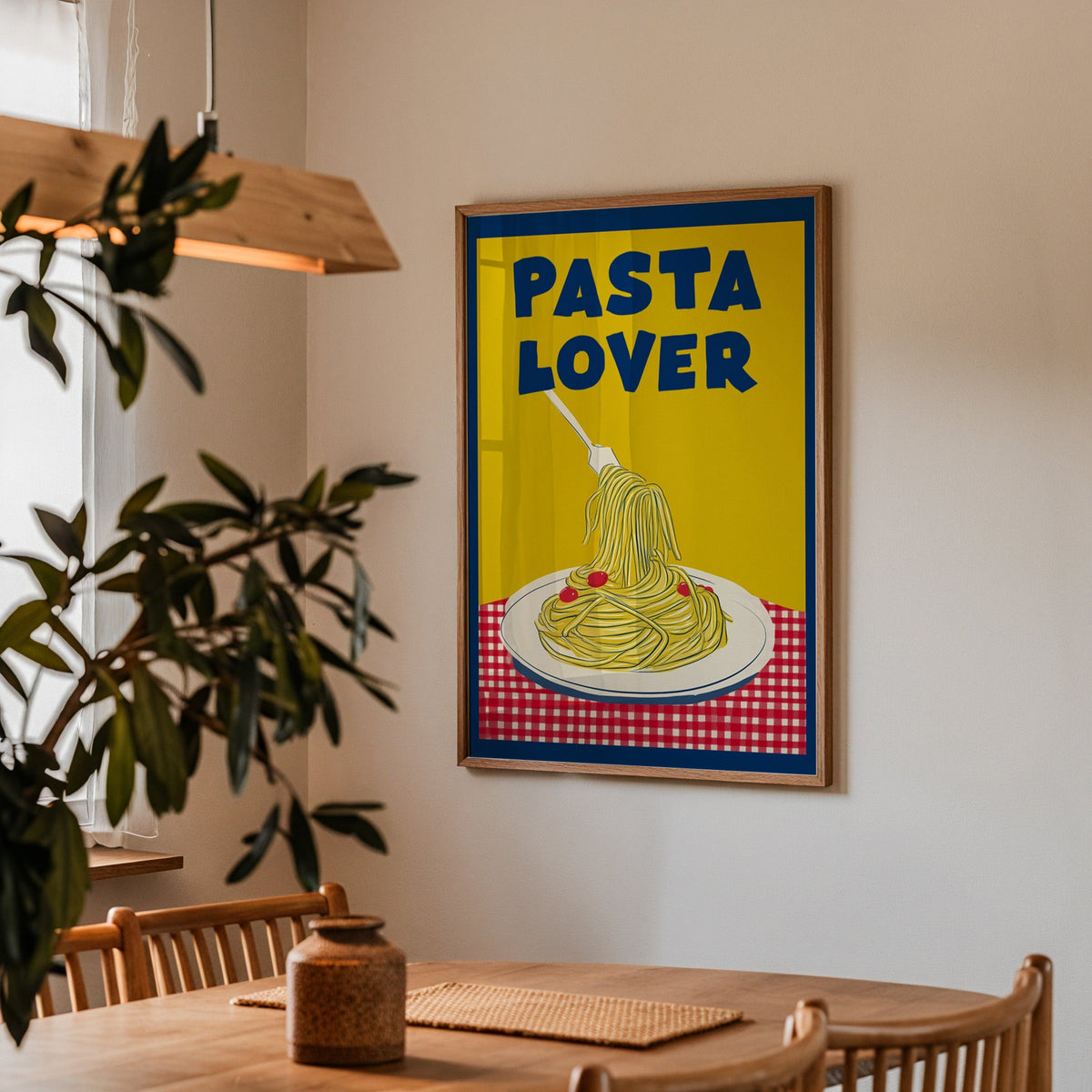 Pasta Lover yellow print in a walnut frame above a dining table with olive branches