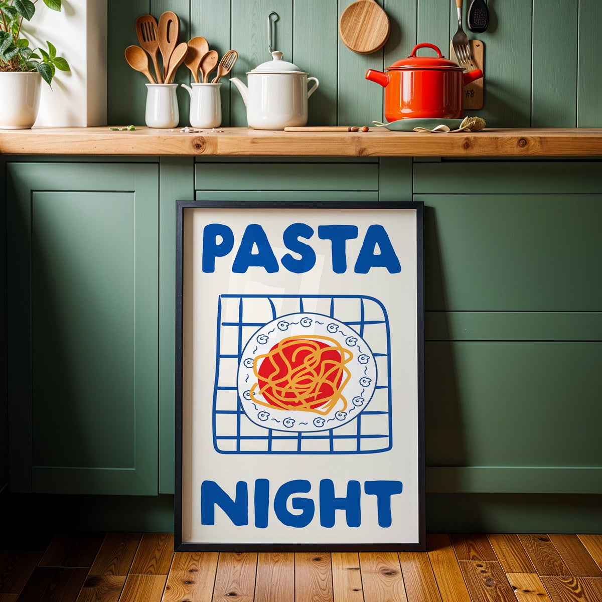 Pasta night blue print in a black frame against sage green kitchen cabinets