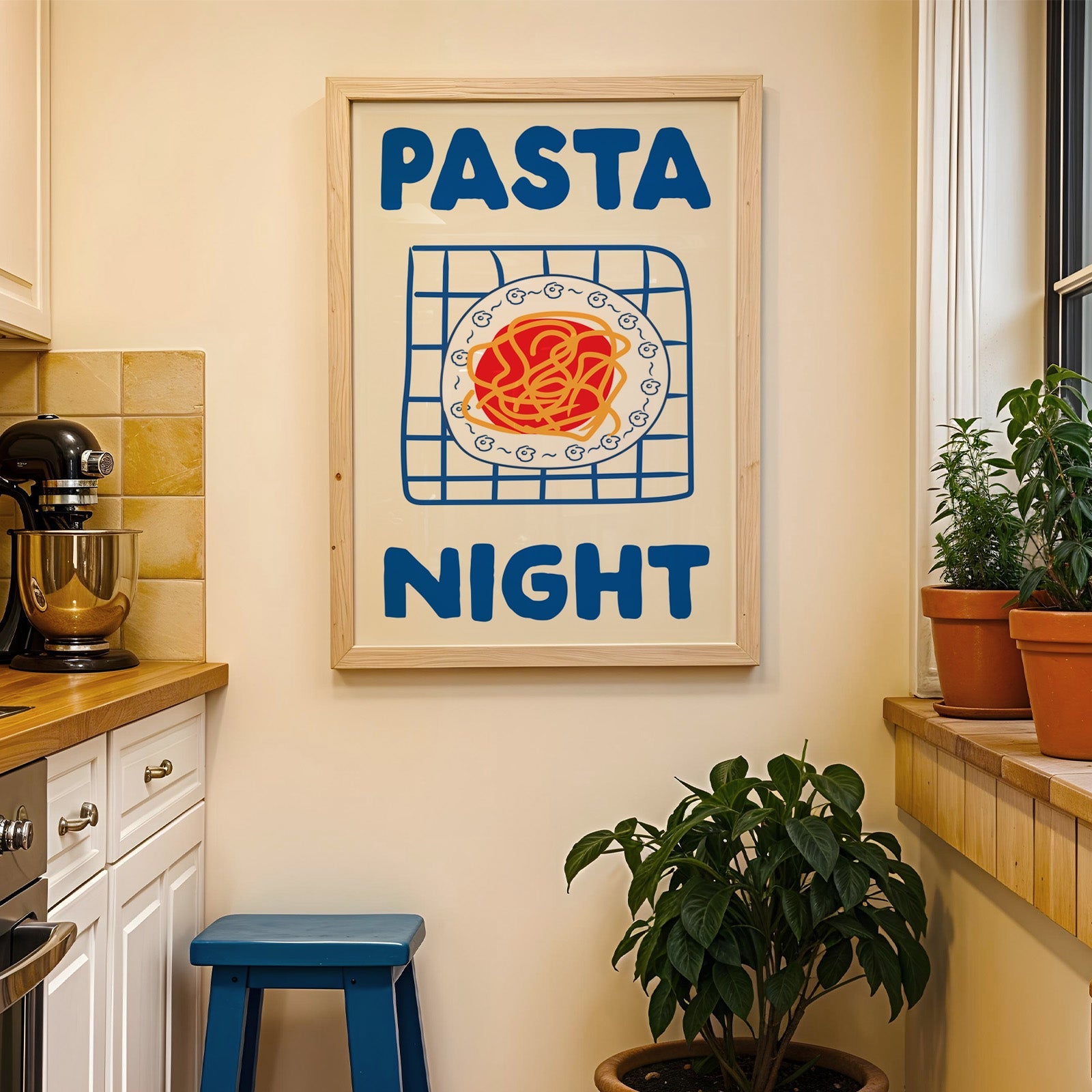 Pasta night blue print in a wood frame on a yellow tiled kitchen wall