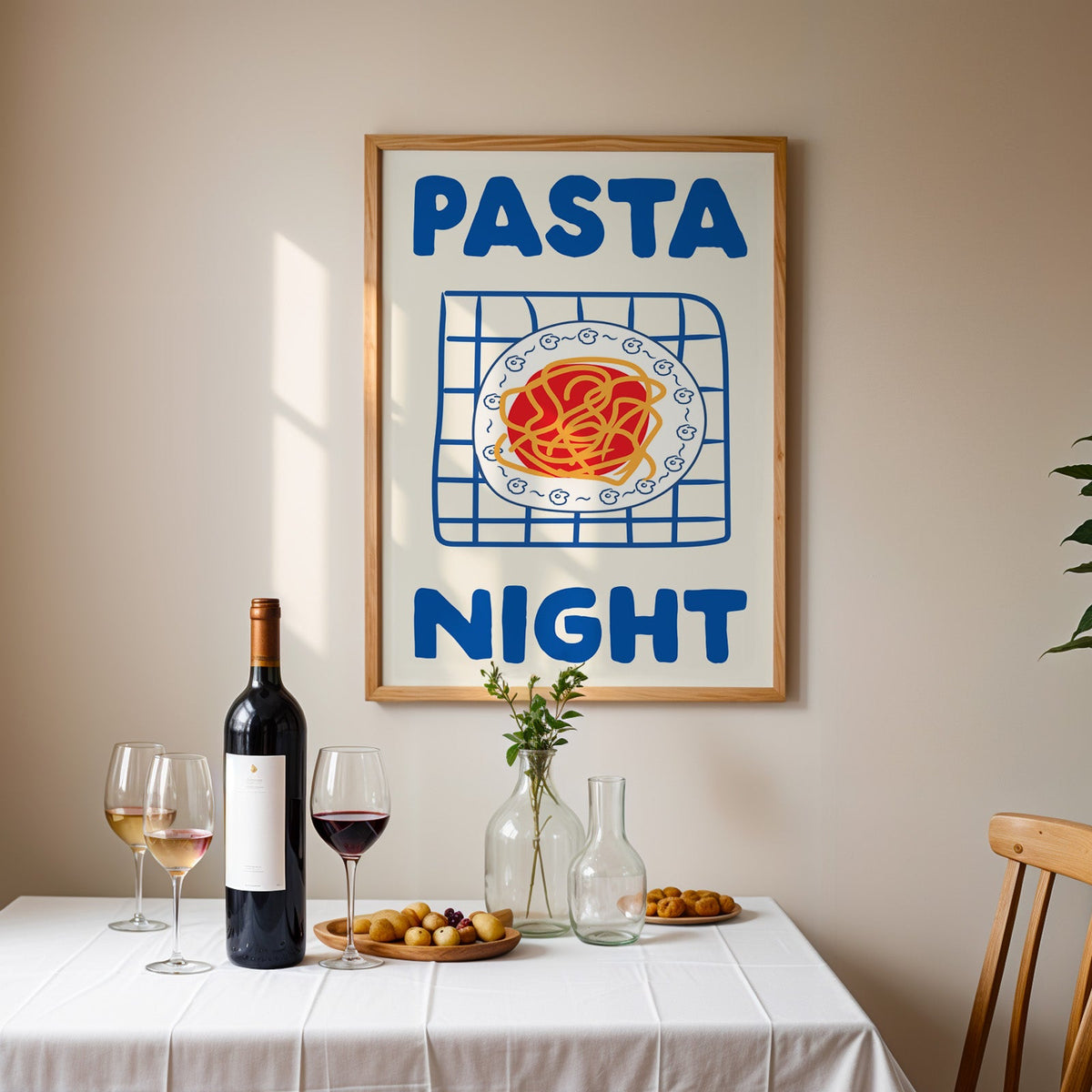 Pasta night blue print in an oak frame above a table laid with red wine and glasses