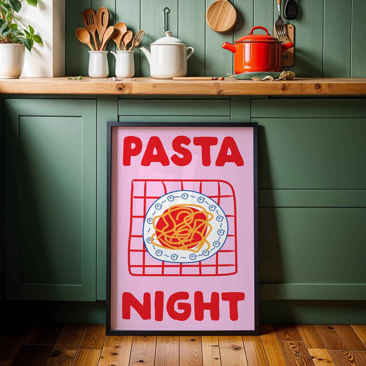 Pasta night pink print in a black frame against sage green kitchen cabinets