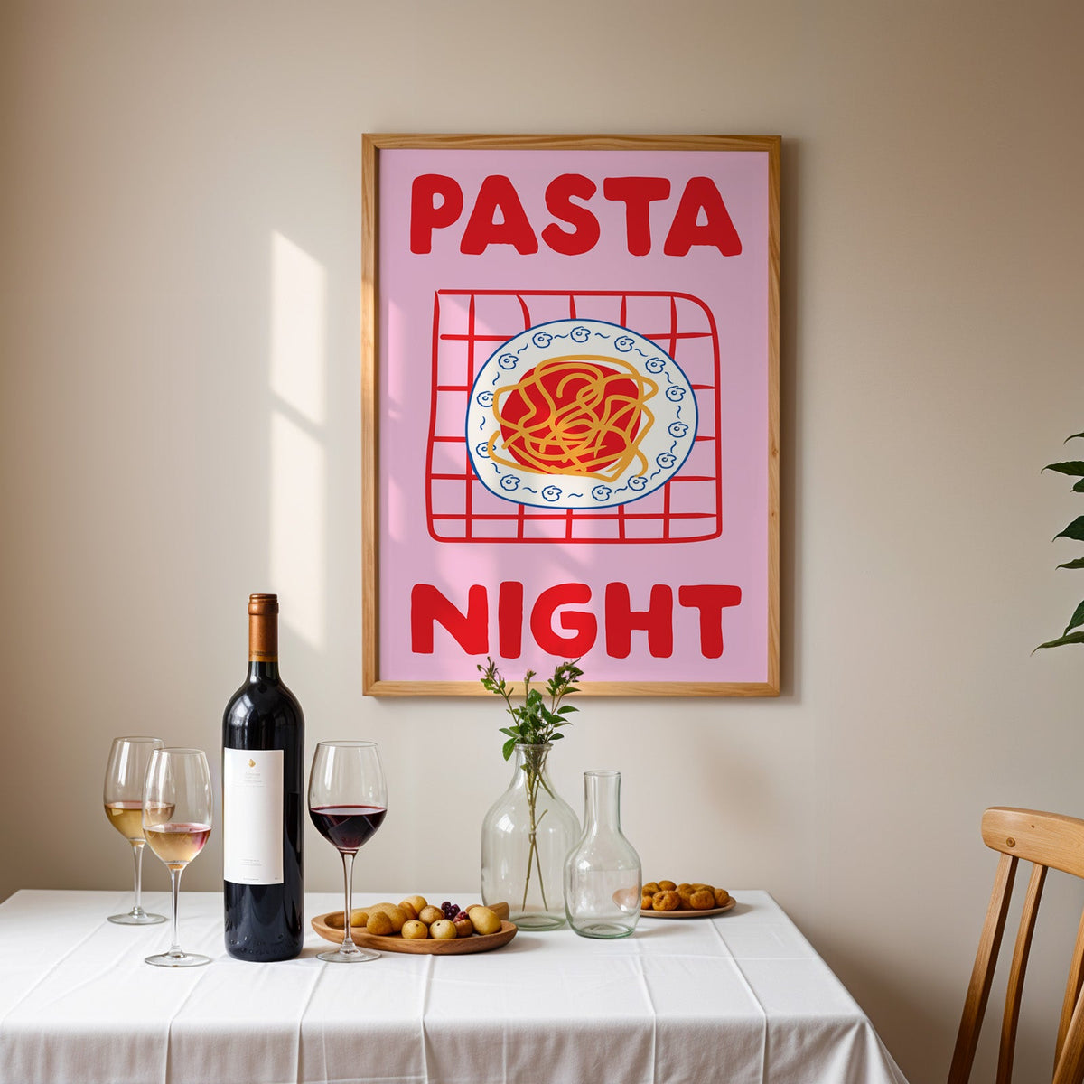 Pasta night pink print in an oak frame above a table laid with red wine and glasses