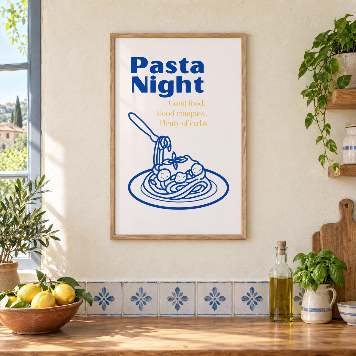Pasta Night cobalt spaghetti and meatballs print in an oak frame on a cream plaster wall above a worktop with a bowl of lemons and blue-and-white tiles