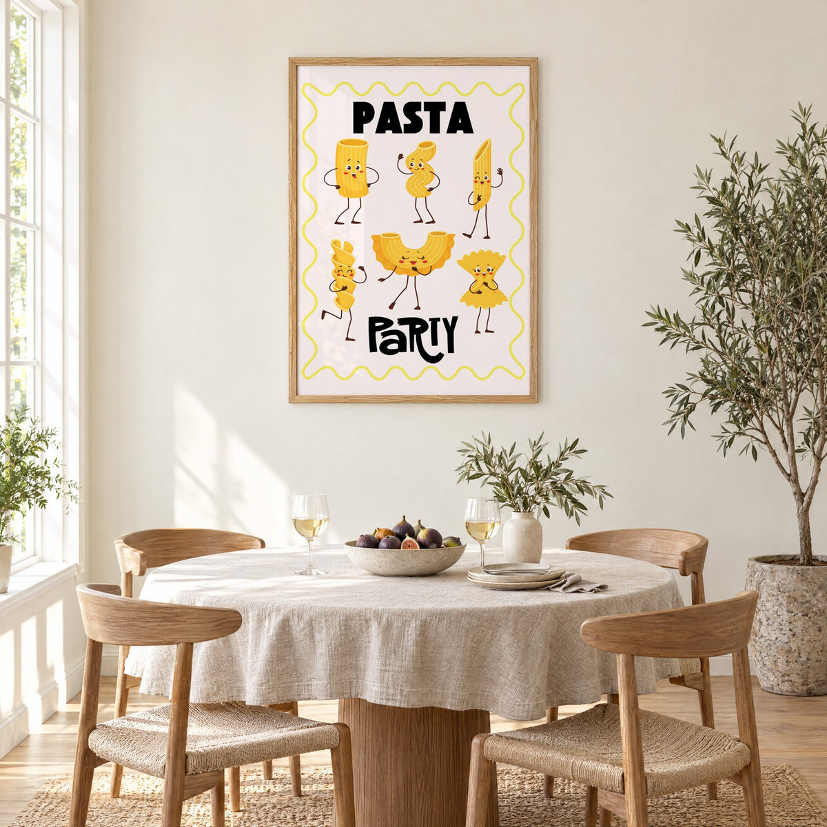 Pasta Party cartoon noodles print in an oak frame above a round linen-covered dining table with figs and wine