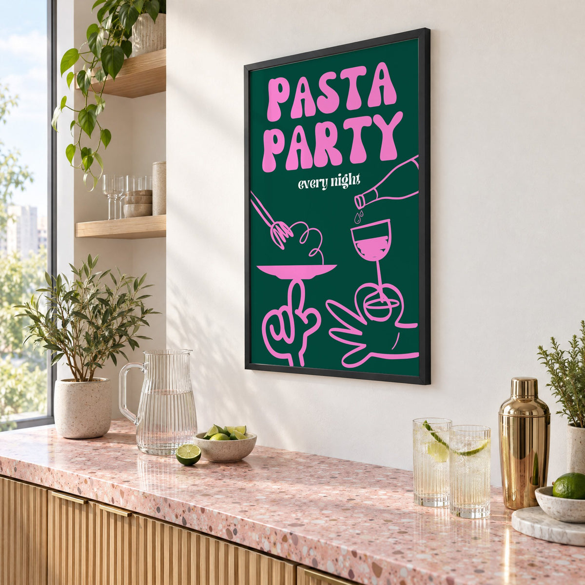Pasta Party every night green print in a black frame above a pink terrazzo cocktail counter with limes, seen at an angle
