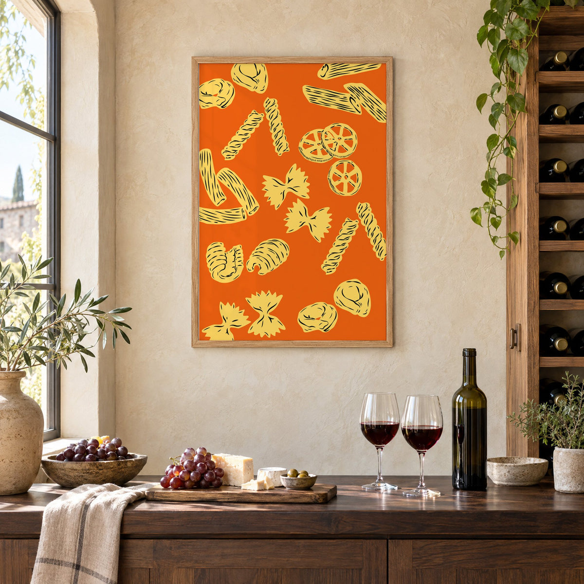 Orange pasta pattern woodcut-style print in an oak frame on a limewashed wall above a wine counter with red wine, cheese and grapes