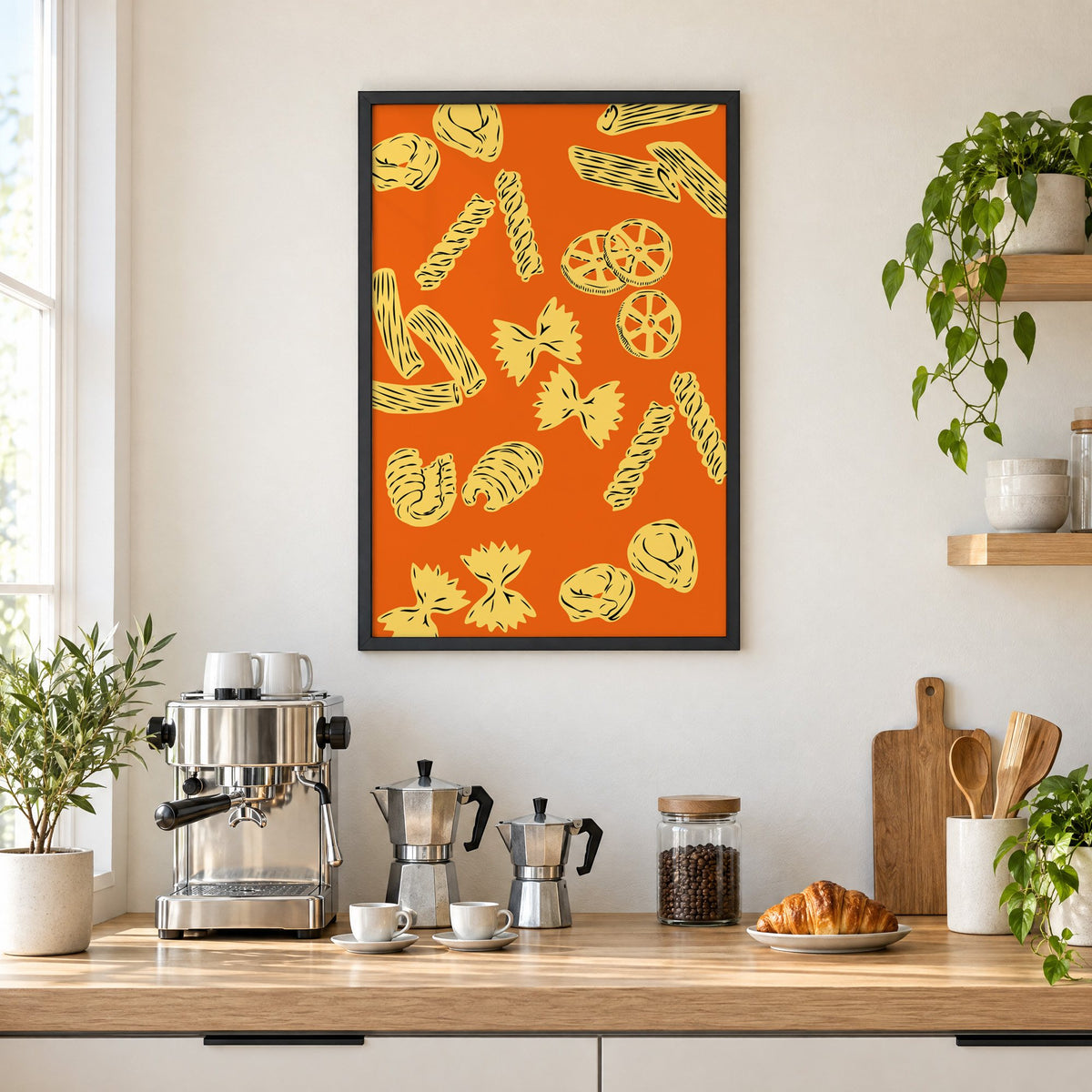 Orange pasta pattern woodcut-style print in a black frame above a home espresso bar with moka pots and espresso cups