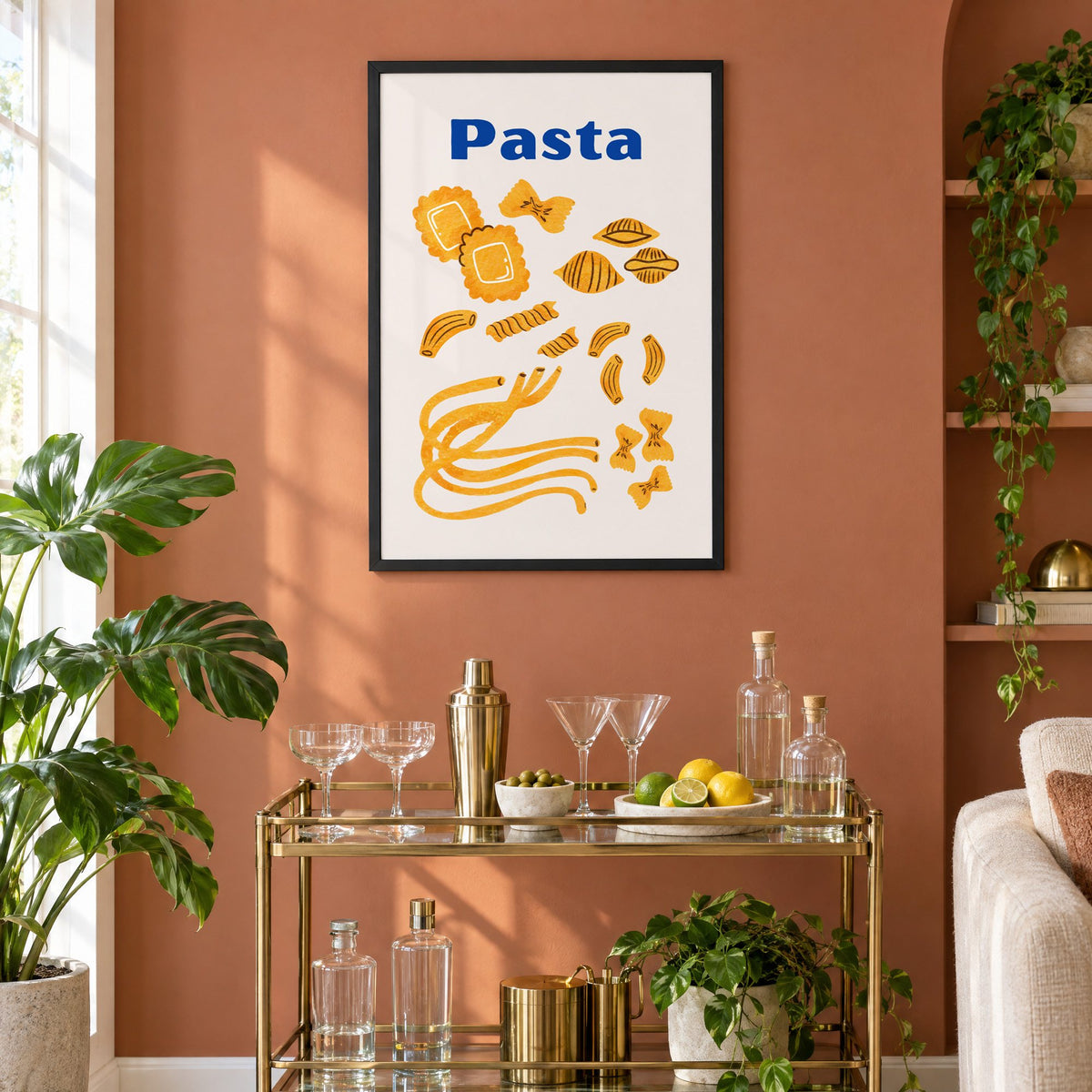 Pasta blue title watercolor pasta shapes print in a black frame on a terracotta wall above a brass bar cart with coupes and citrus
