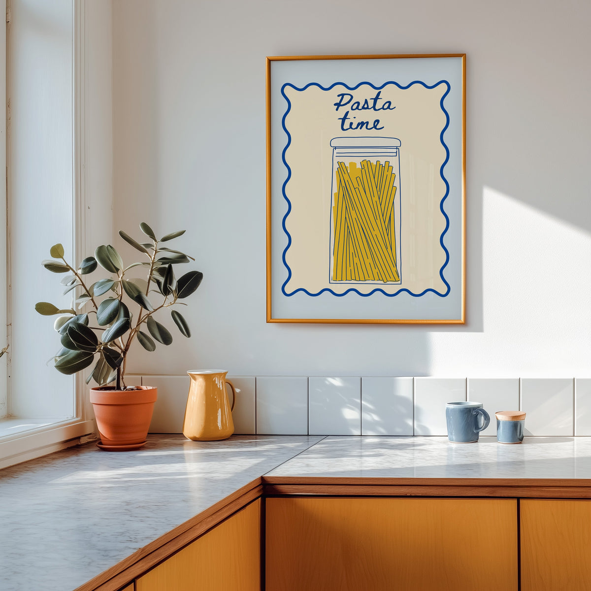 Pasta Time jar print shown in a gold frame above a marble counter in a tan kitchen