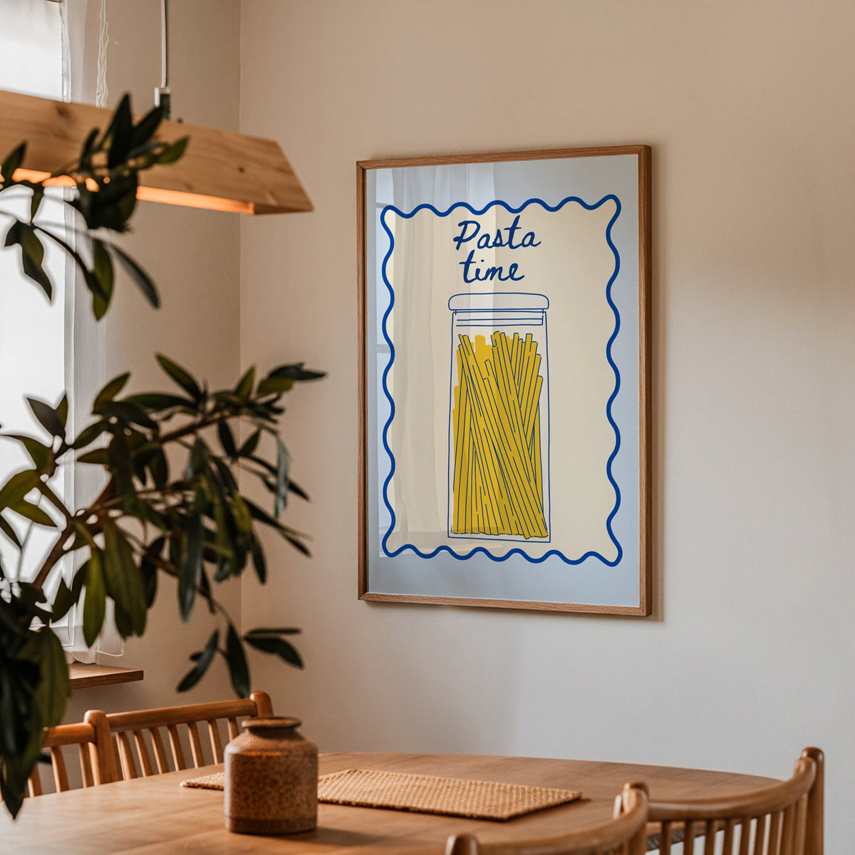 Pasta Time jar print in a walnut frame above a dining table with olive branches